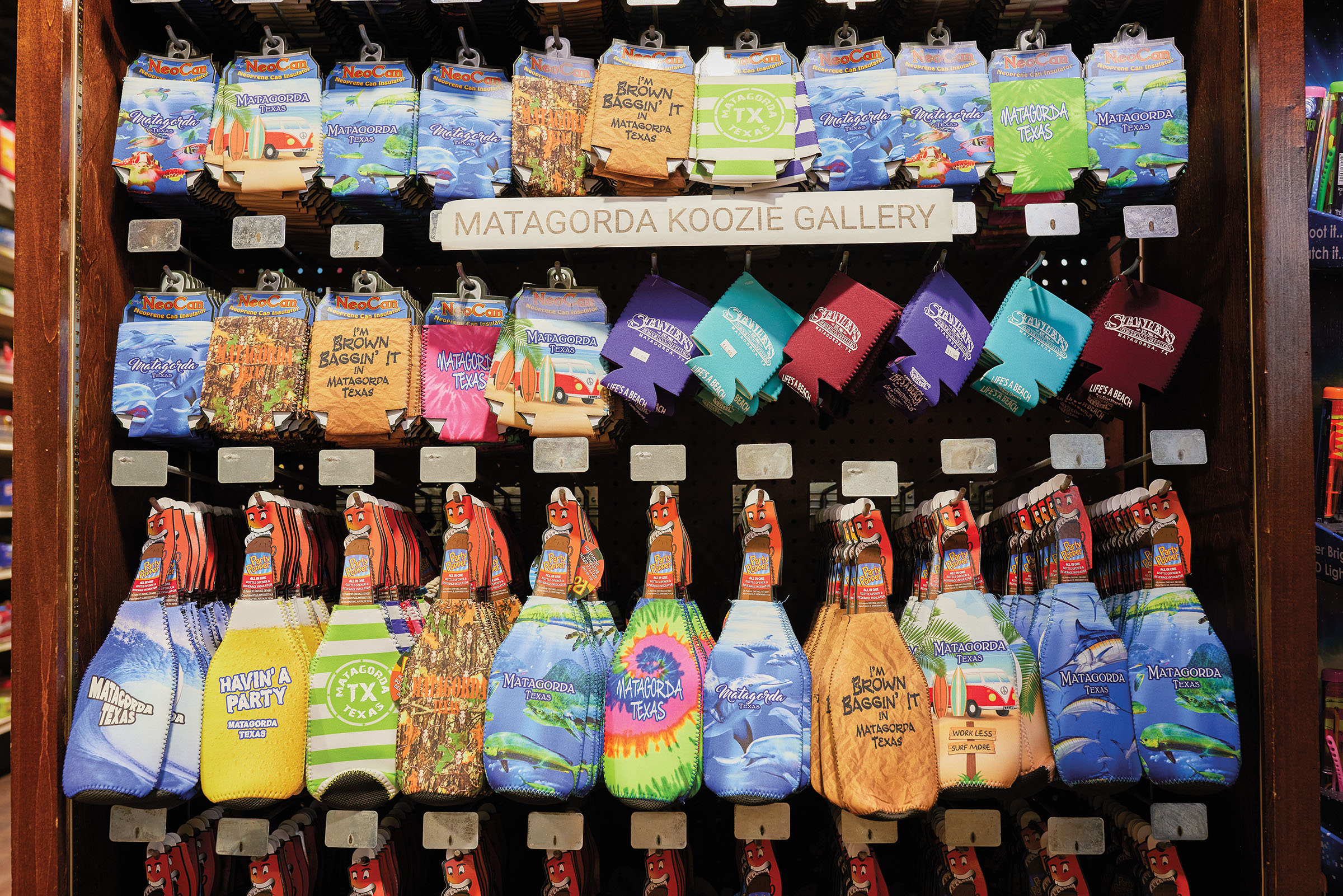 A display of brightly-colored items including koozies and socks in tie-dye saying Matagorda