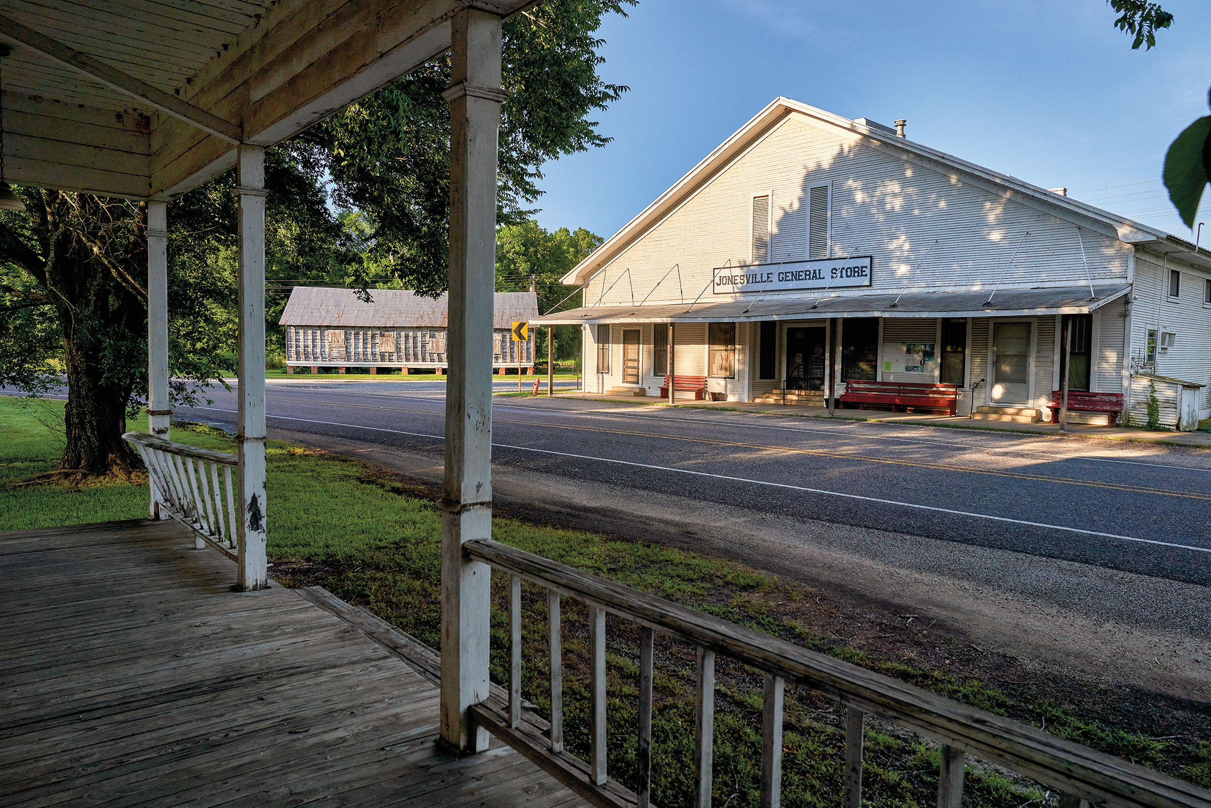 The view of a white store from across a wooden porch