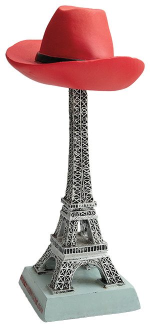 A small figurine of an Eiffel tower with a red cowboy hat