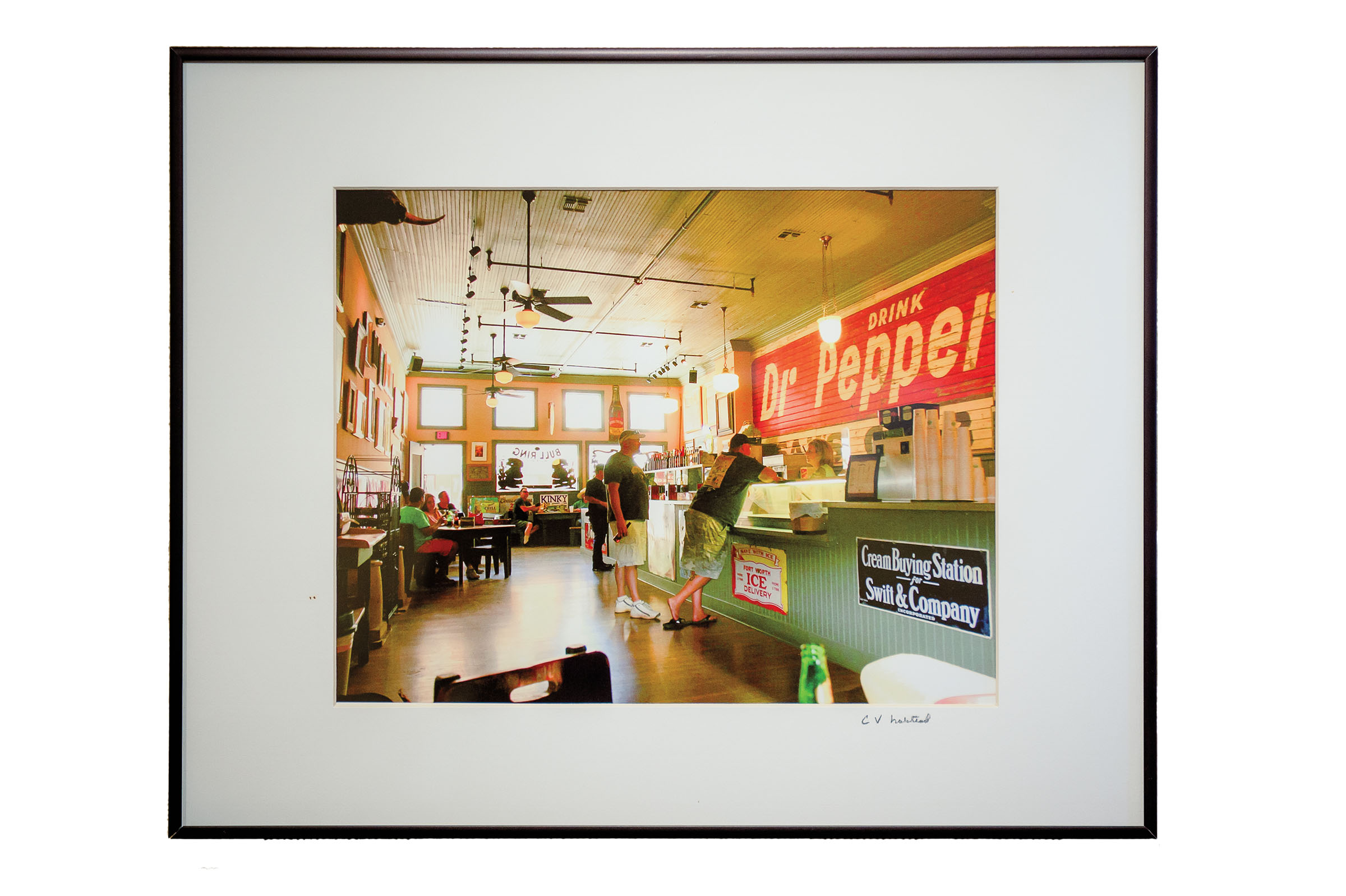 A framed photograph of a vintage museum with a large sign reading Dr Pepper