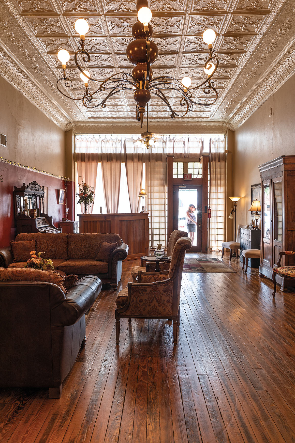 The inside of an ornate hotel with dark wood floors and vintage furniture
