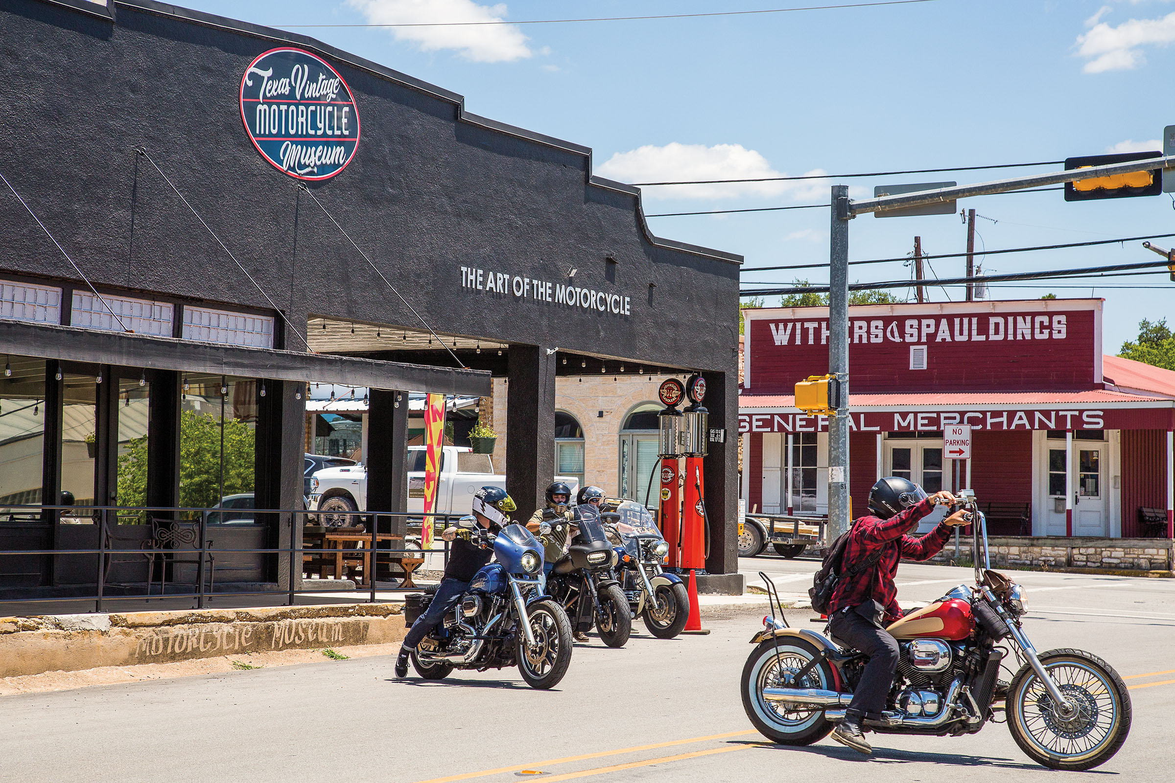 A collection of motorcycles outside of a gray building