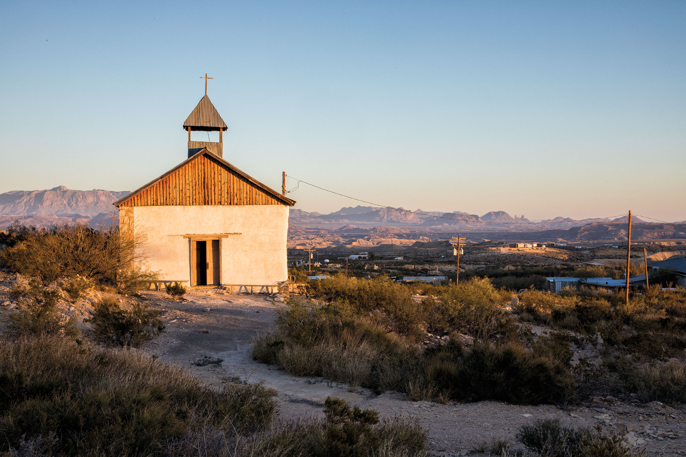 A chapel on a hill bathed in golden evening light