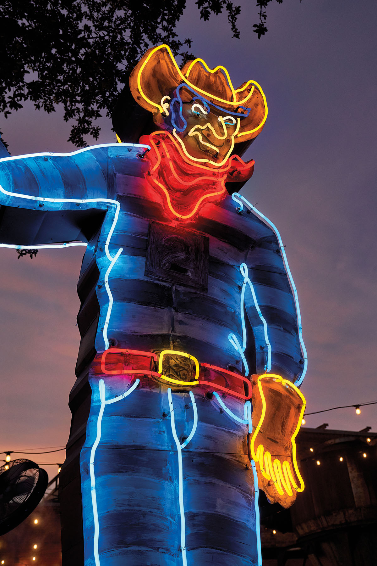 A neon sculpture with red, blue and yellow in the shape of a cowboy