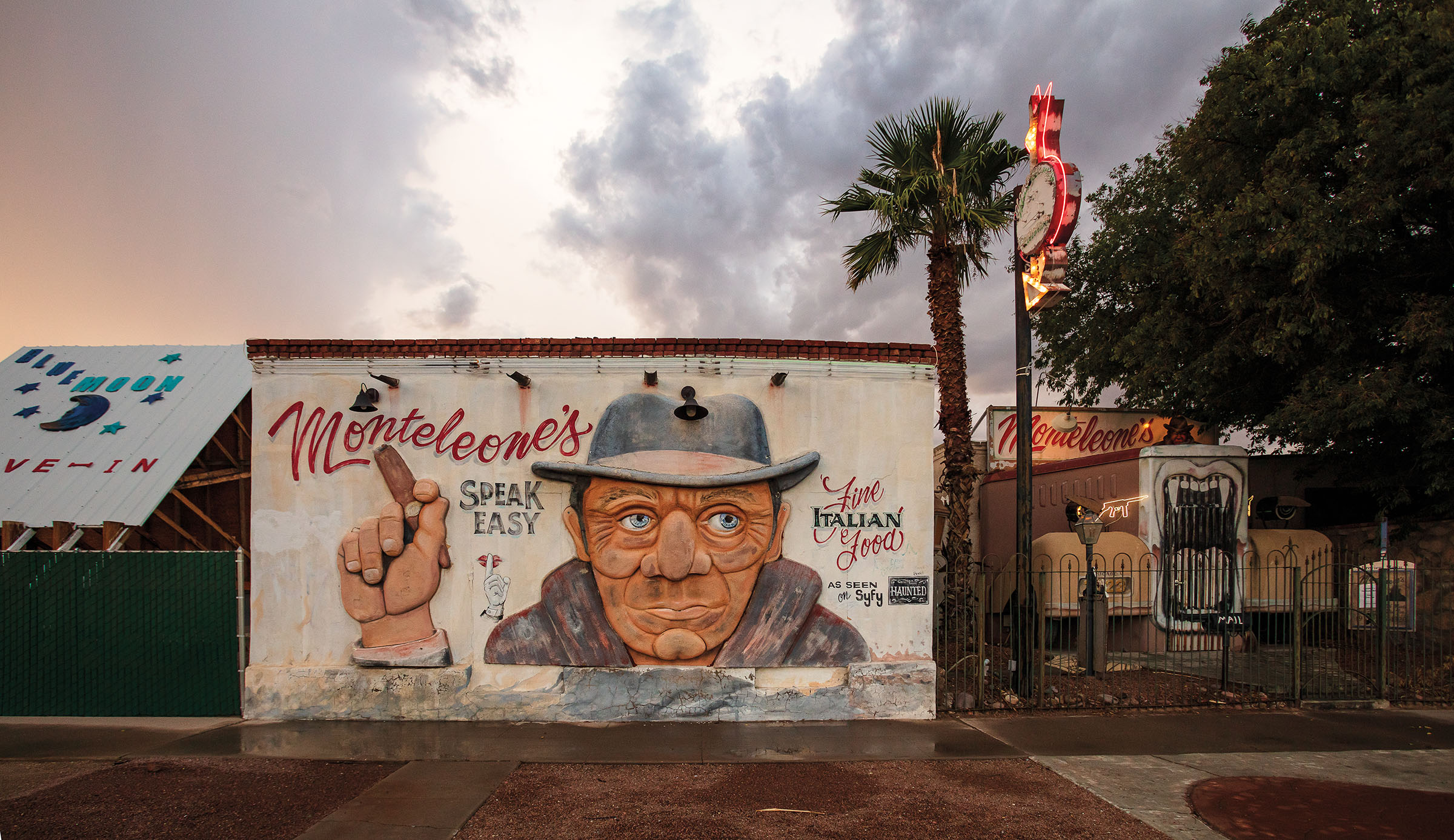 A mural of a man holding a cigar with text reading "Monteleone's Speak Easy" and "Fine Italian food"