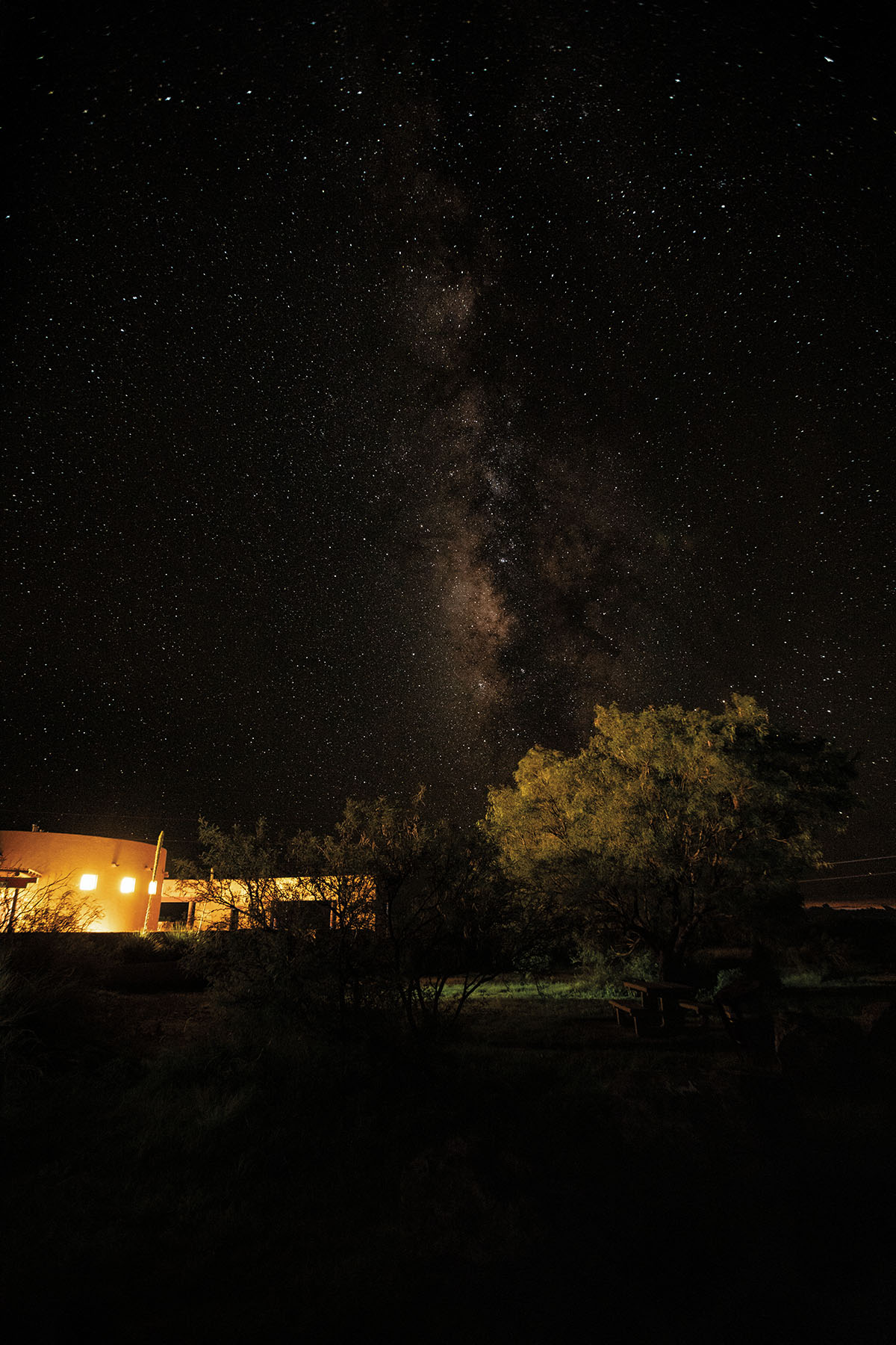 A lighted visitor center is the only thing illuminiated in this night sky photo of the stars over Marfa