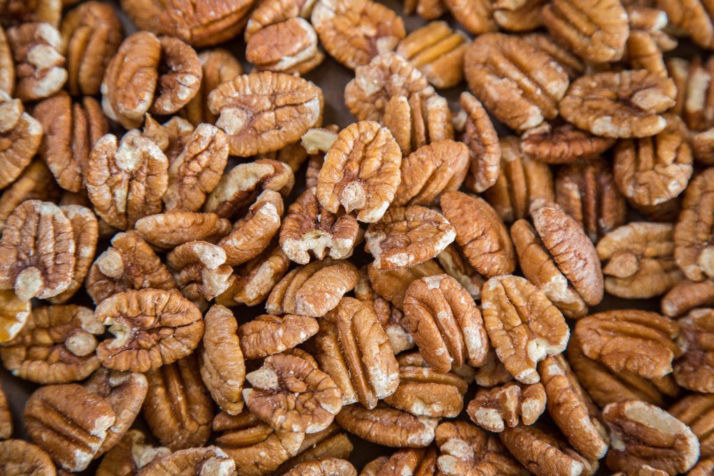 A pile of toasted brown pecan nuts