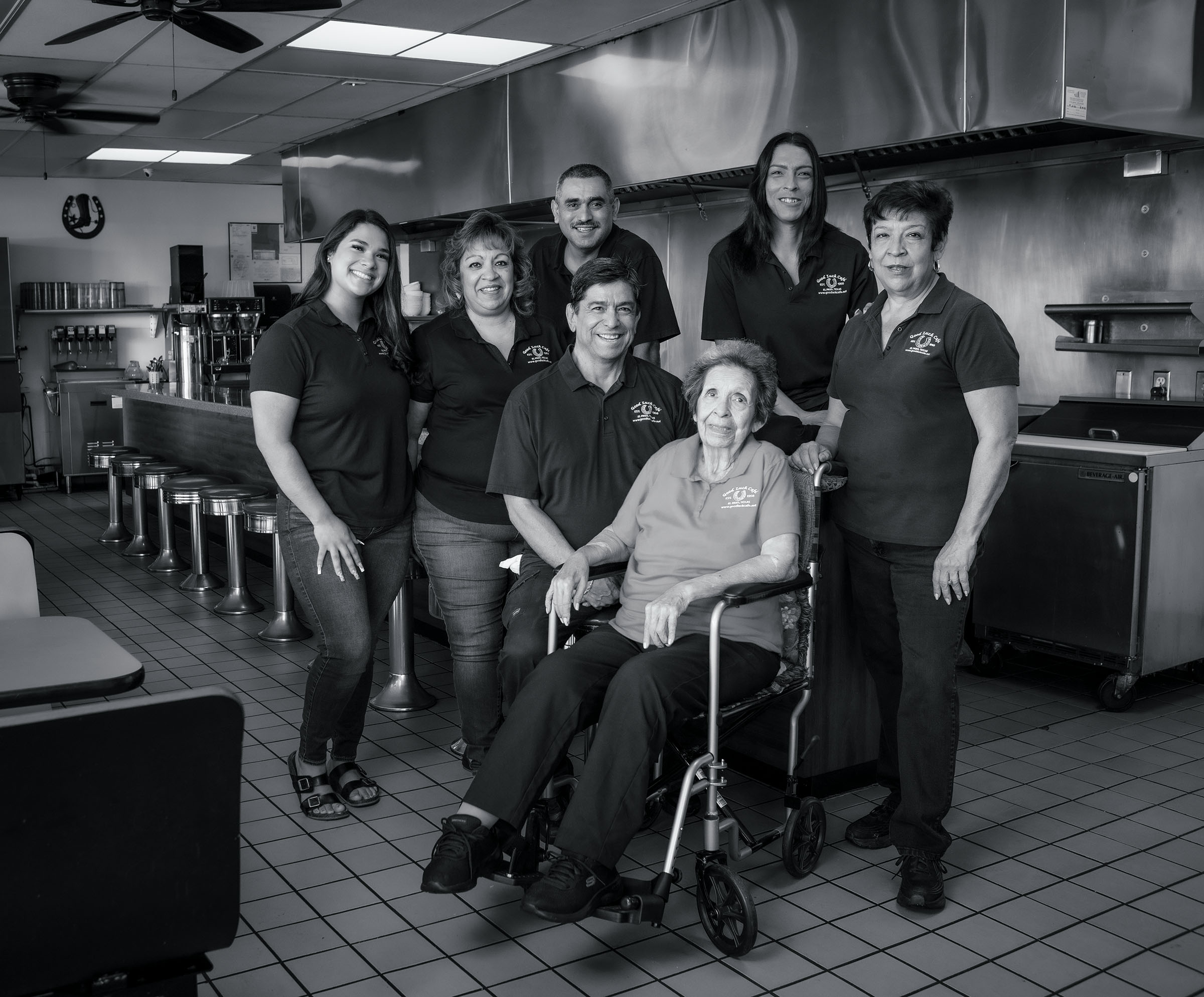 A group of people pose for a photo in a restaurant kitchen