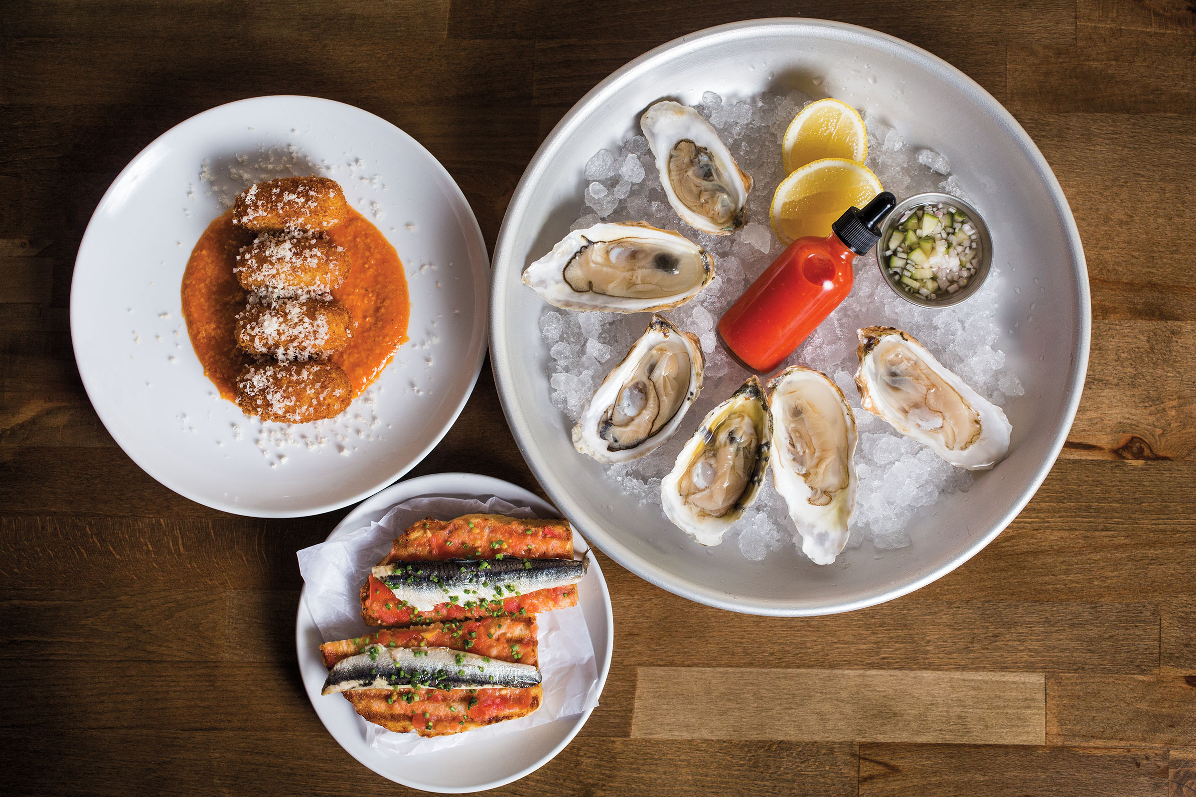 An overhead view of plates of food on a wooden table