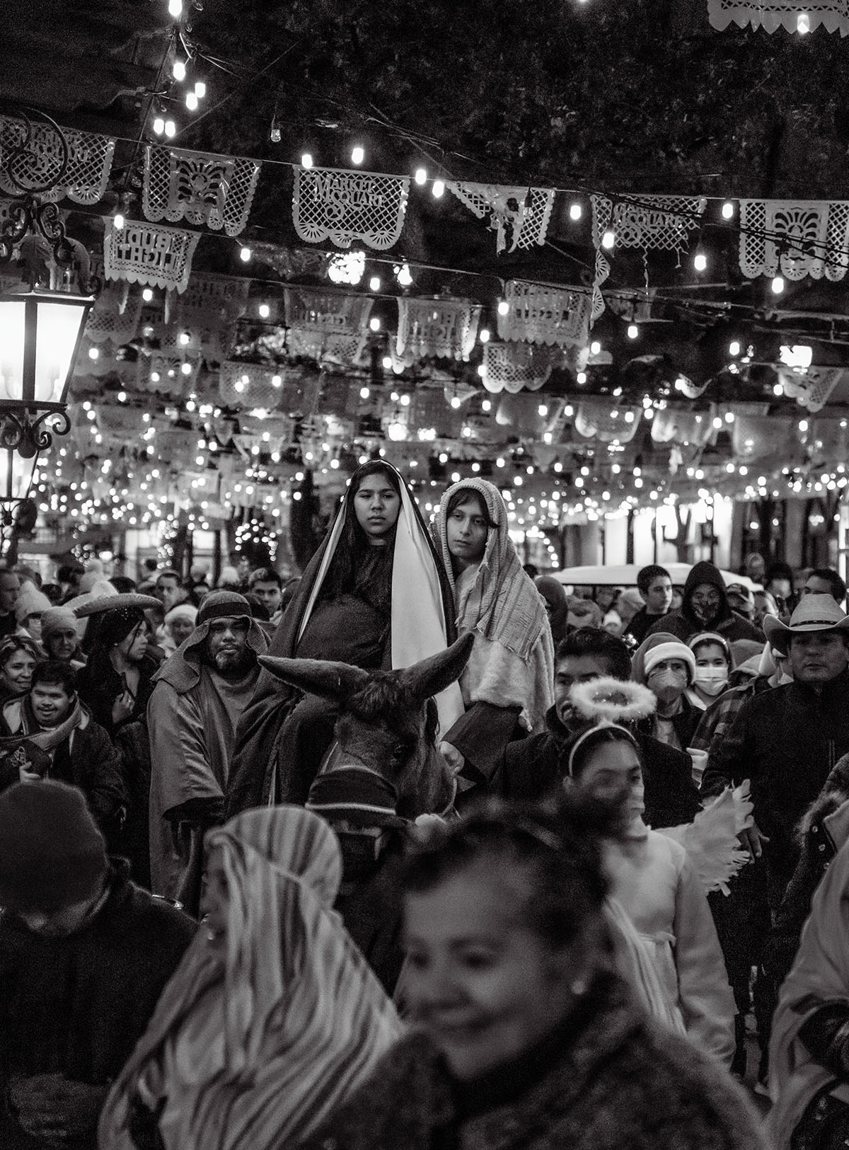 A large group of people in a festive atmosphere with candles, lights, and flags