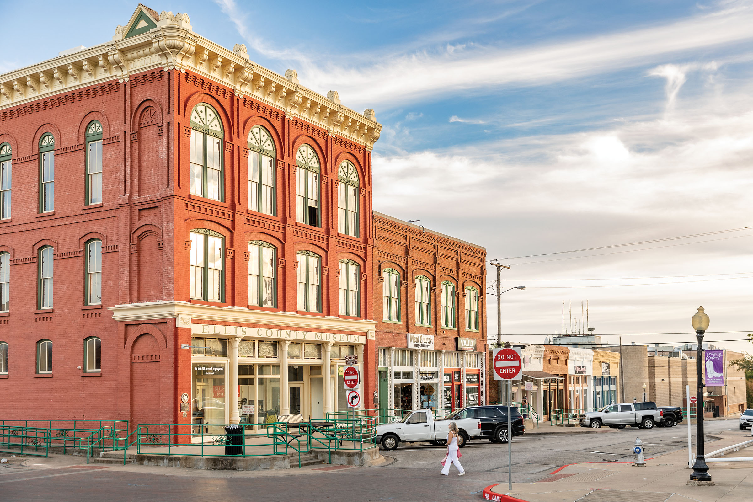 A brick building on a historic town square under blue sky