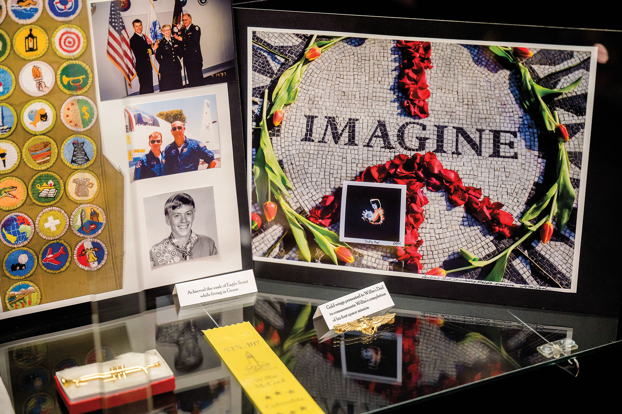 A collection of memorabilia and photos including a picture of a brick circle with the words "Imagine"