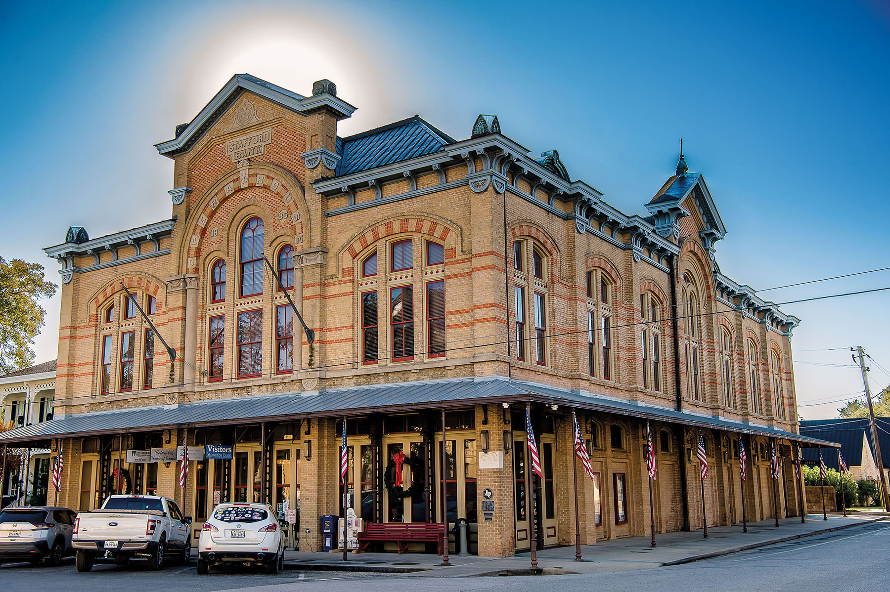 The exterior of a brick building with ornate tops under a blue sky