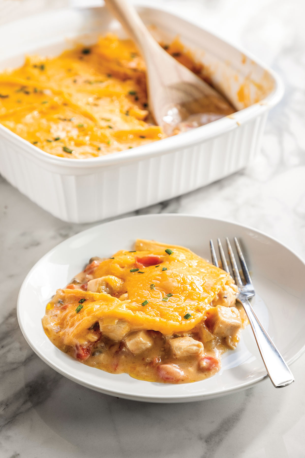 Bright yellow casserole with large pieces of chicken and beans