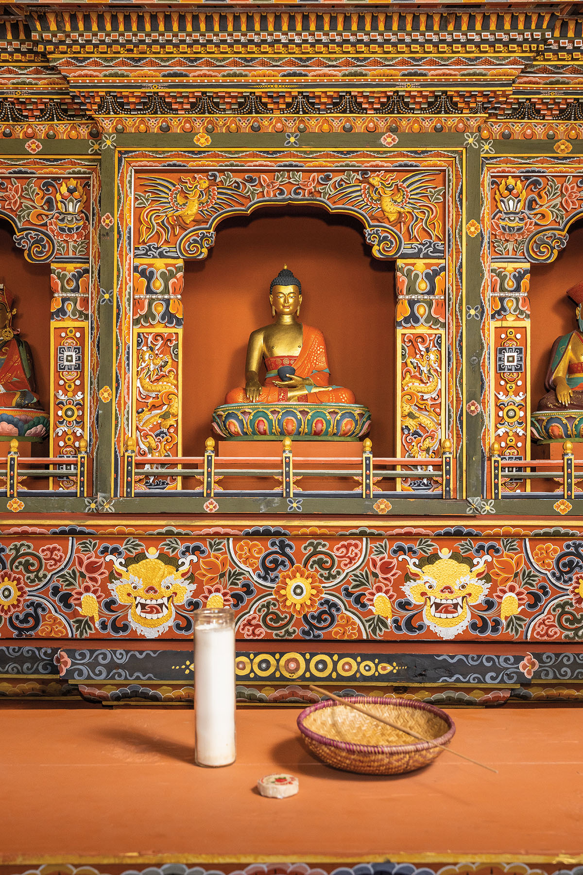 A statue of a golden figure sitting cross-legged in an ornately decorated archway