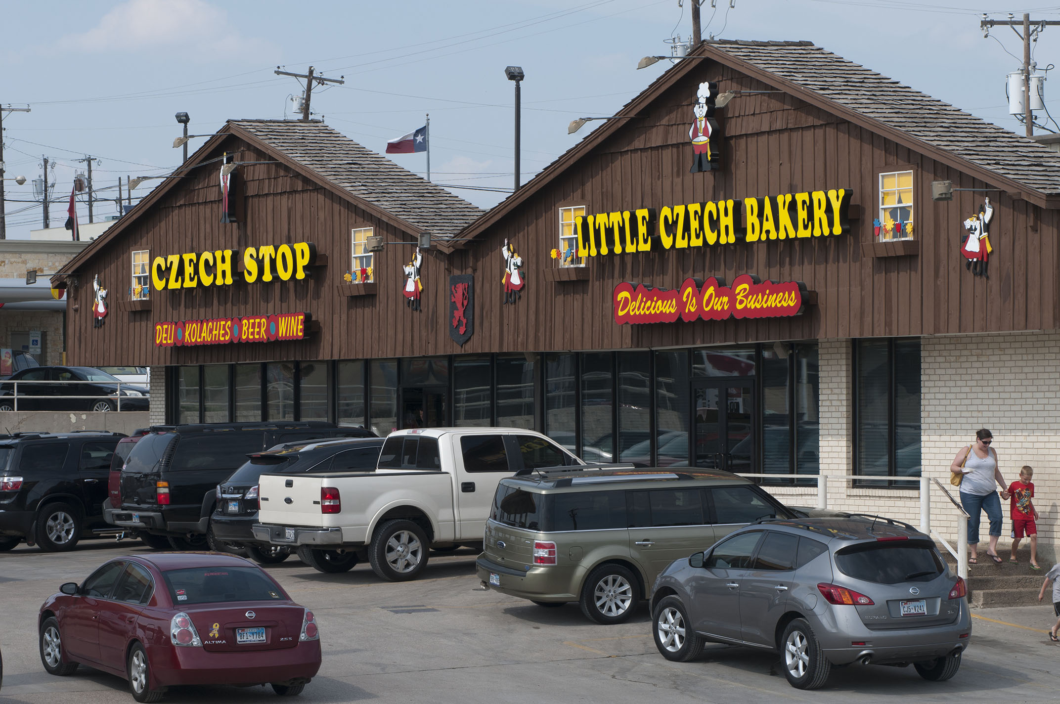A view of the exterior of both Czech Stop and the Little Czech Bakery with a full parking lot.