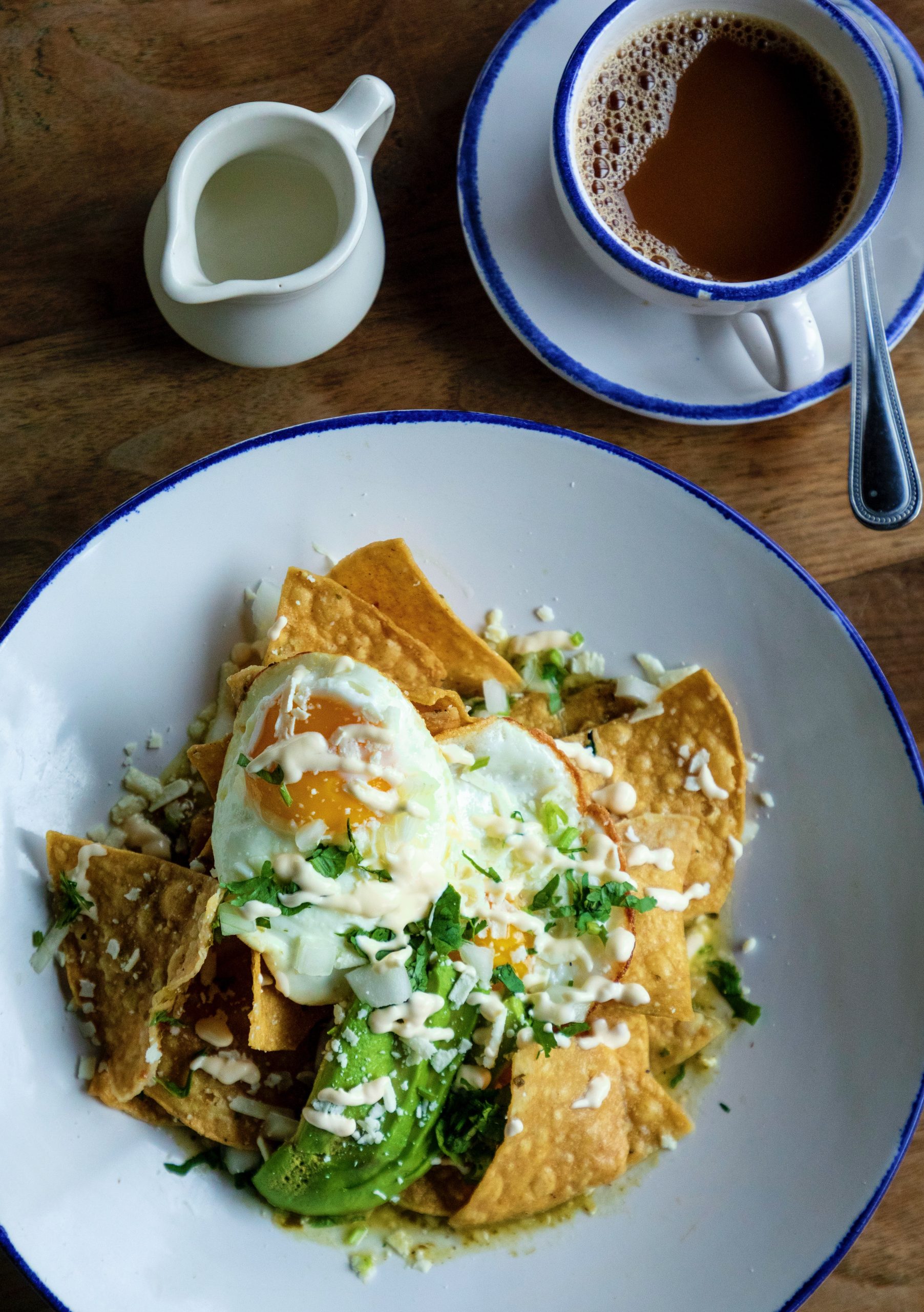 A plate of chilaquiles served with a side of coffee.