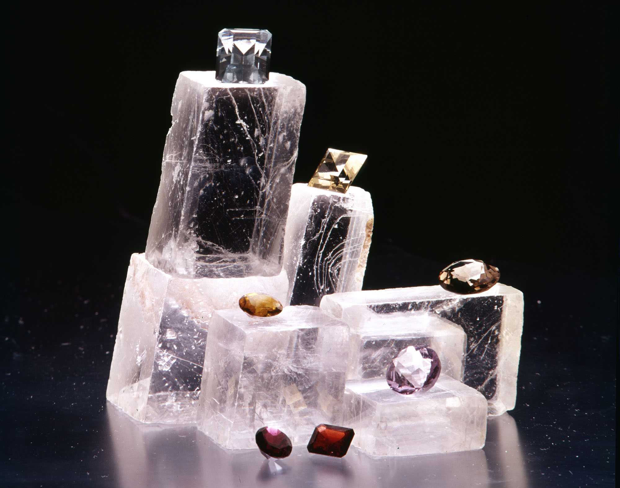 A collection of gemstones on clear calcite on a black background