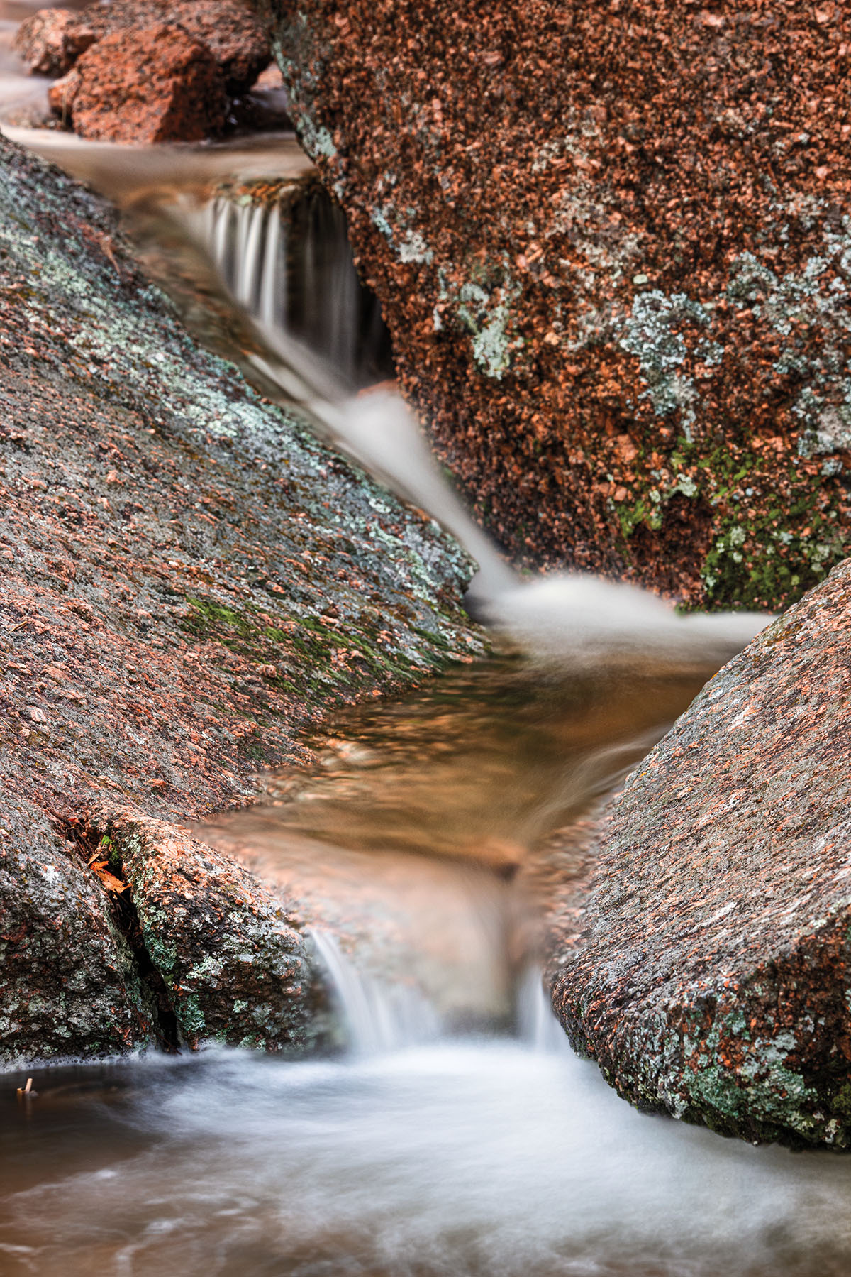 Water flows delicately through red and gray stone 