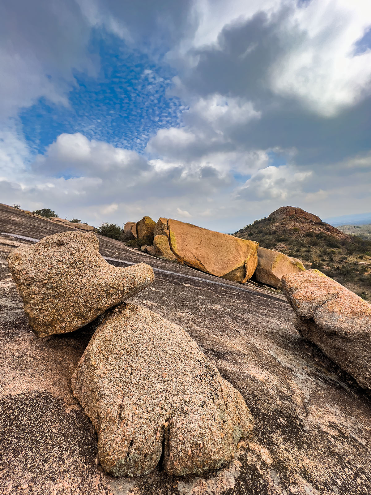 Blue sky and clouds over rock formations on a reddish-gray rock