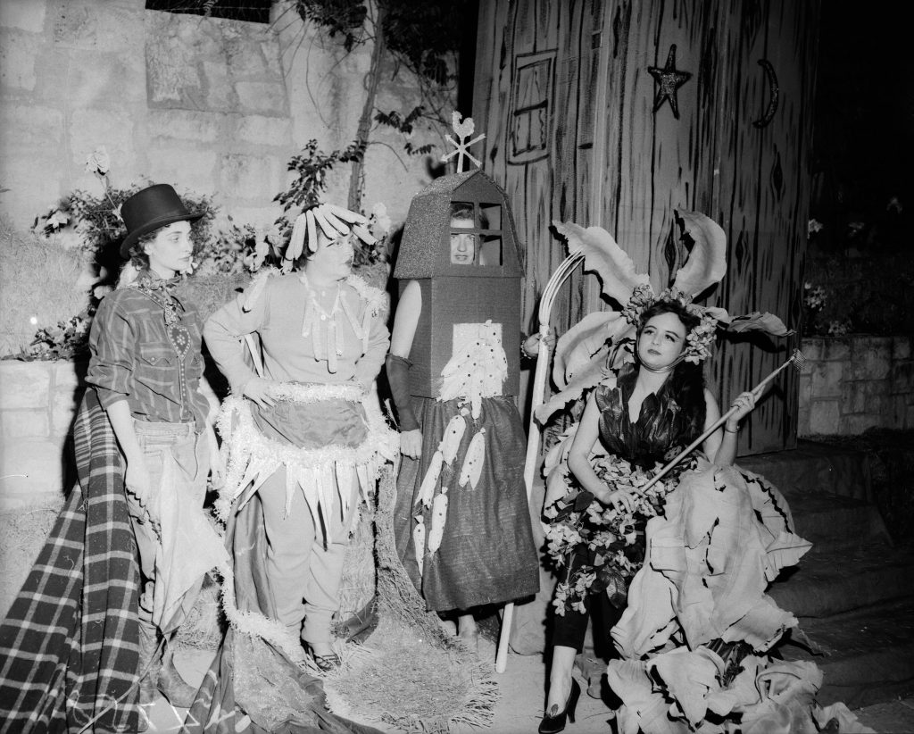 A black and white picture of a group of people in costumes