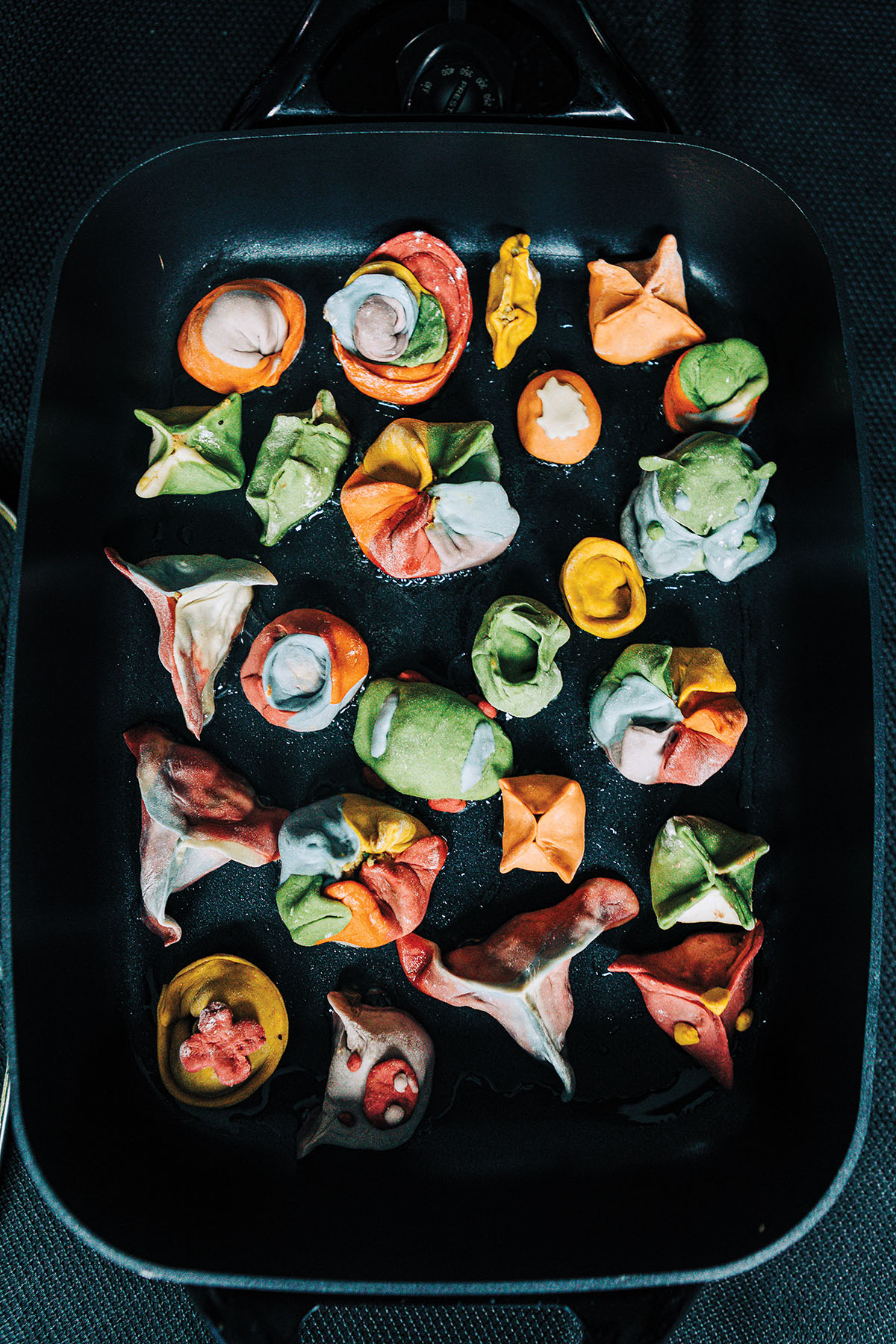An overhead view of a group of colorful dumplings on a dark background