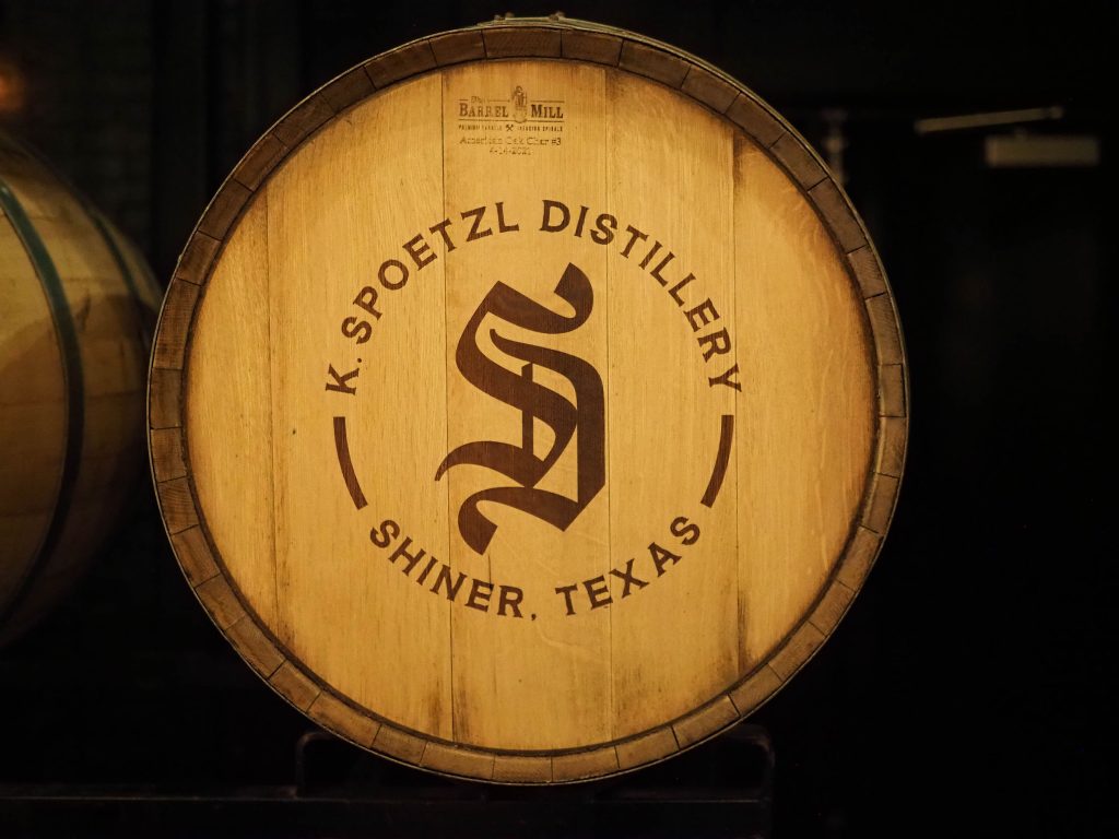 The photo shows the lid of a wooden barrel with the Spoetzl Brewery "S" logo in the middle of a circle with the words "Spoetzl Brewery" curving along the top of the S, and "Shiner, Texas" curving under the S. 