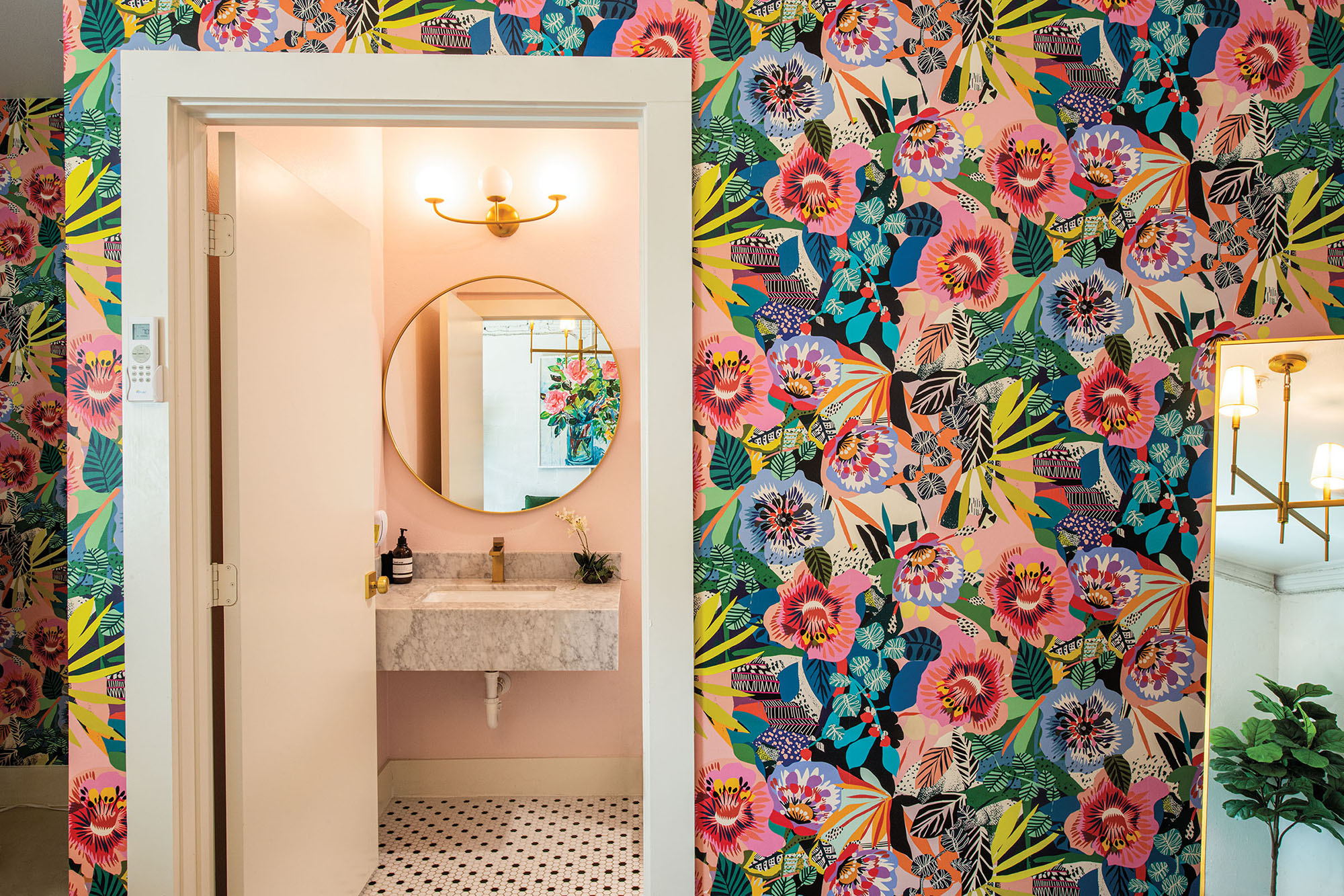 A brightly colored mural adorns a white-paneled doorway with a mirror visible