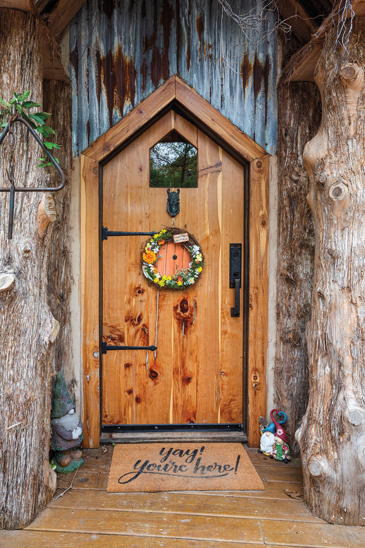 A wooden door with a small colorful wreath