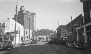 A black and white photograph of downtown Mineral Wells with a sign reading "Welcome to Mineral Wells, home of crazy"