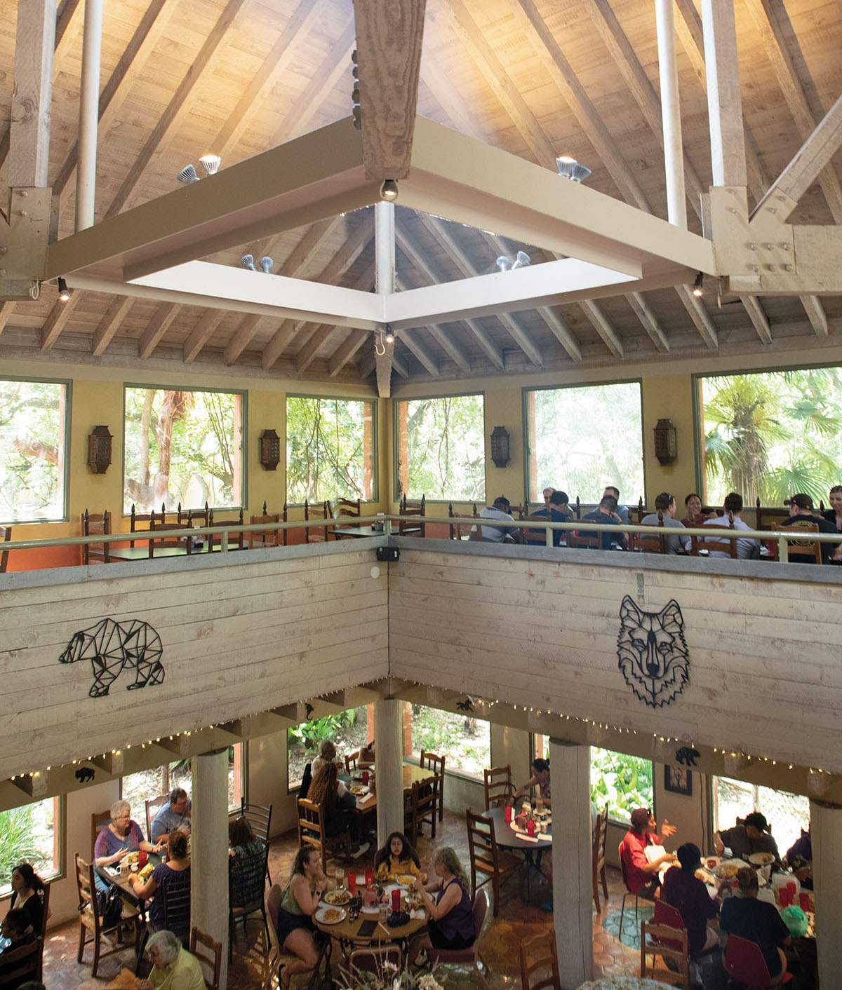 The interior of a restaurant with tall ceilings and a massive skylight