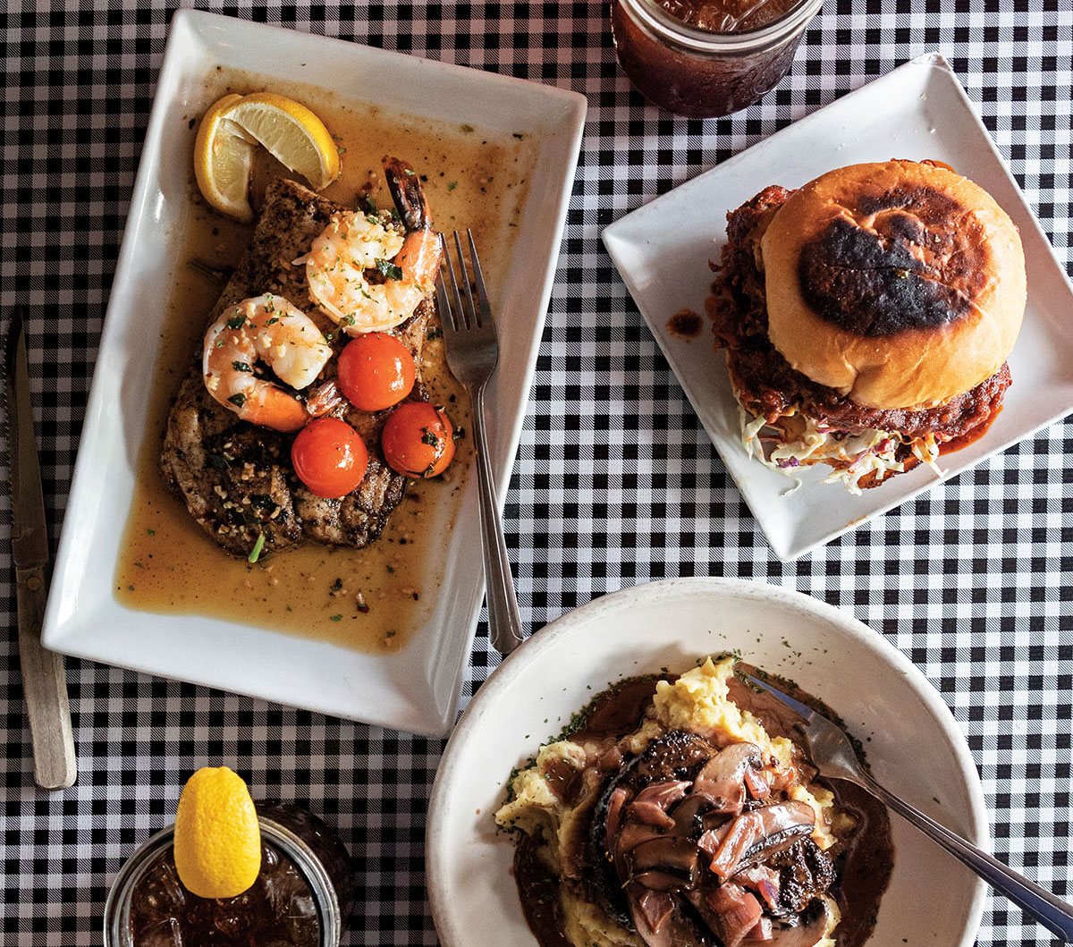 An overhead view of various dishes on a black and white tablecloth