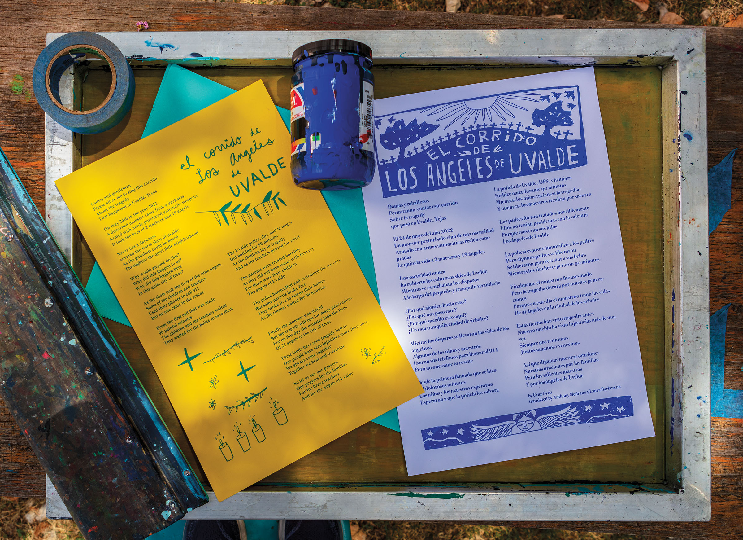 An overhead view of several prints with type and a bottle of ink