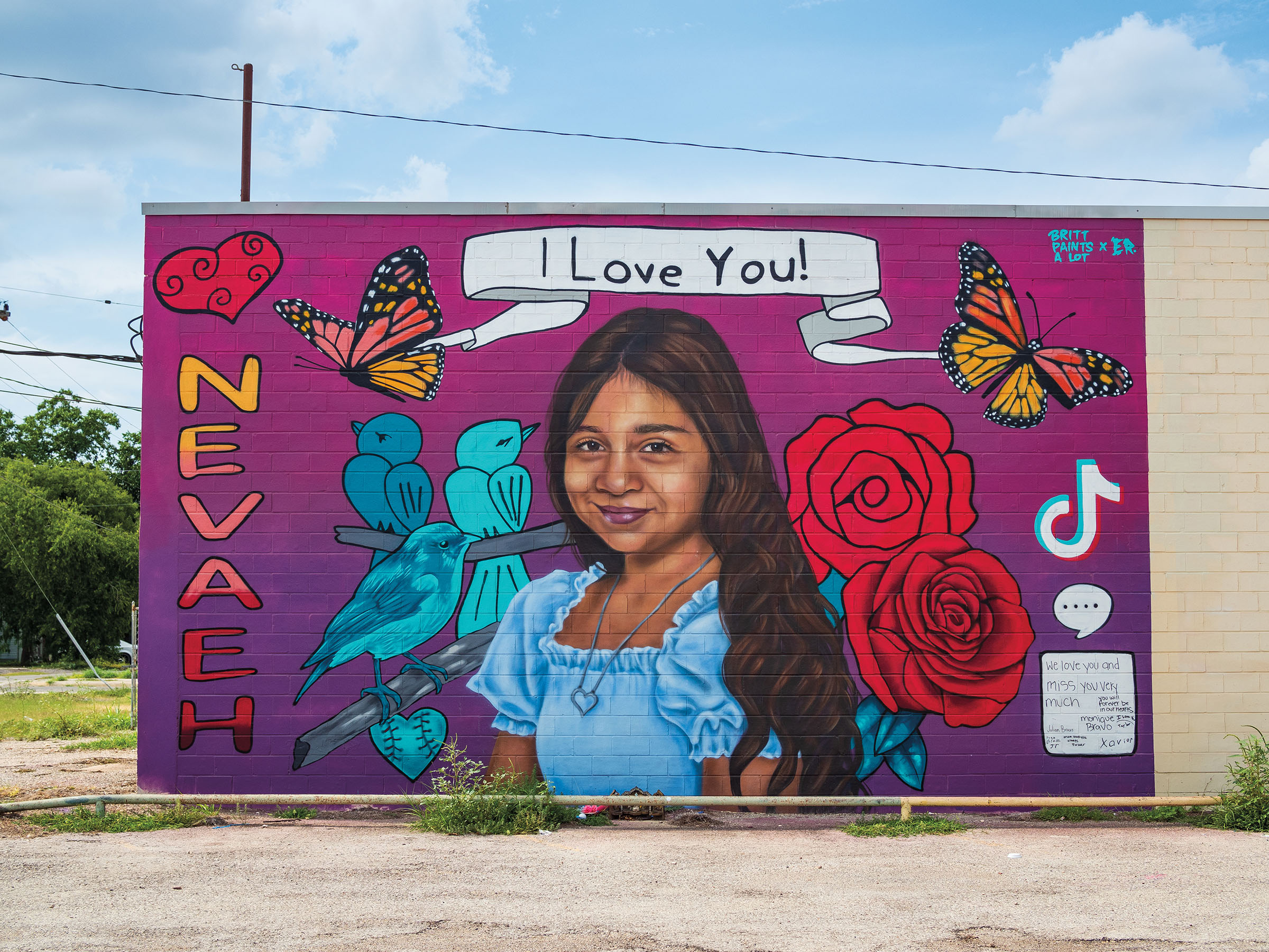 A mural of a young woman on a purple background with a white banner reading "I love you"