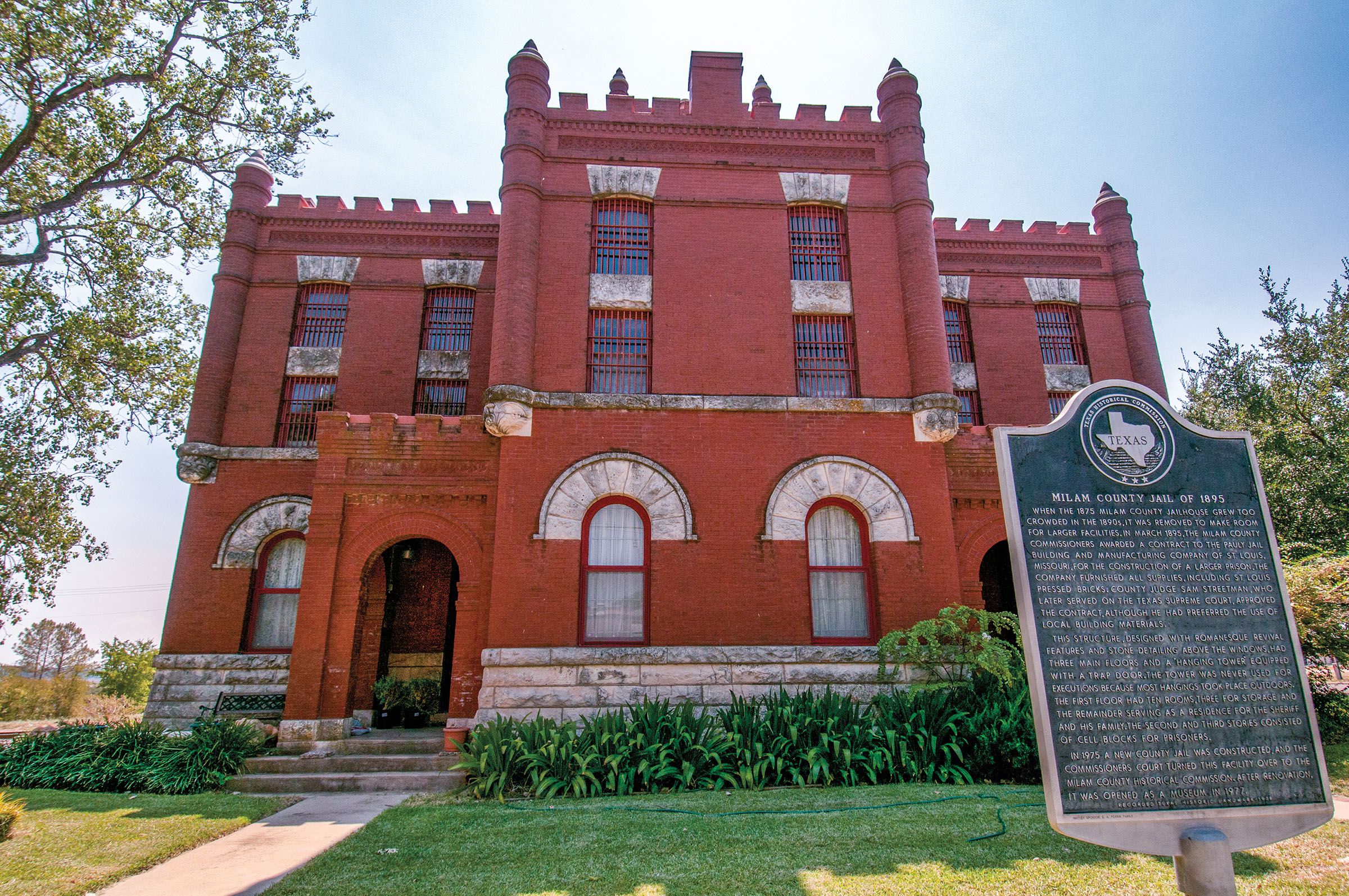 The exterior of a red brick courthouse with a Texas historical marker