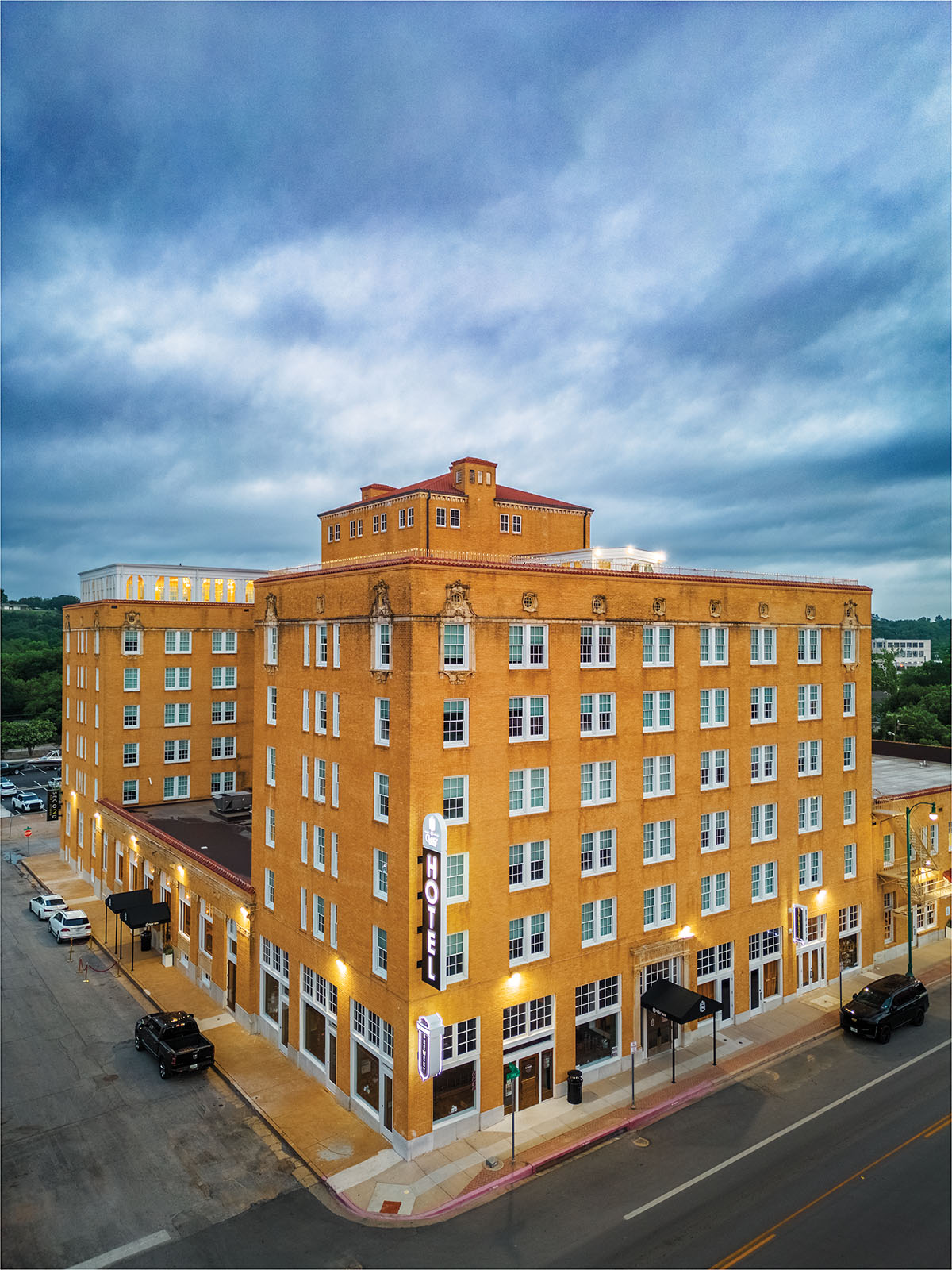 The exterior of a golden brick building under a stormy blue-gray sky