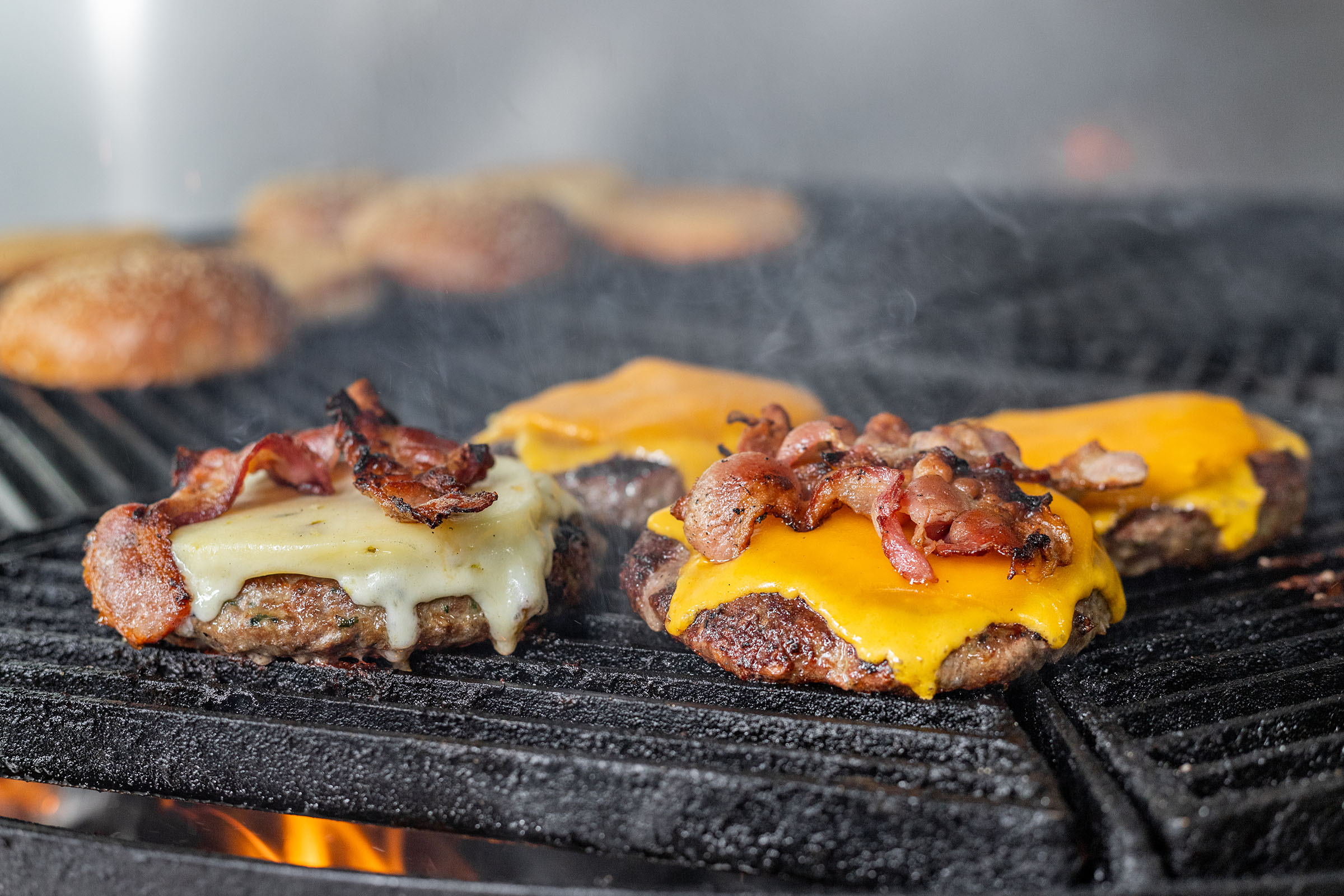 color photo of bacon cheeseburger on grill