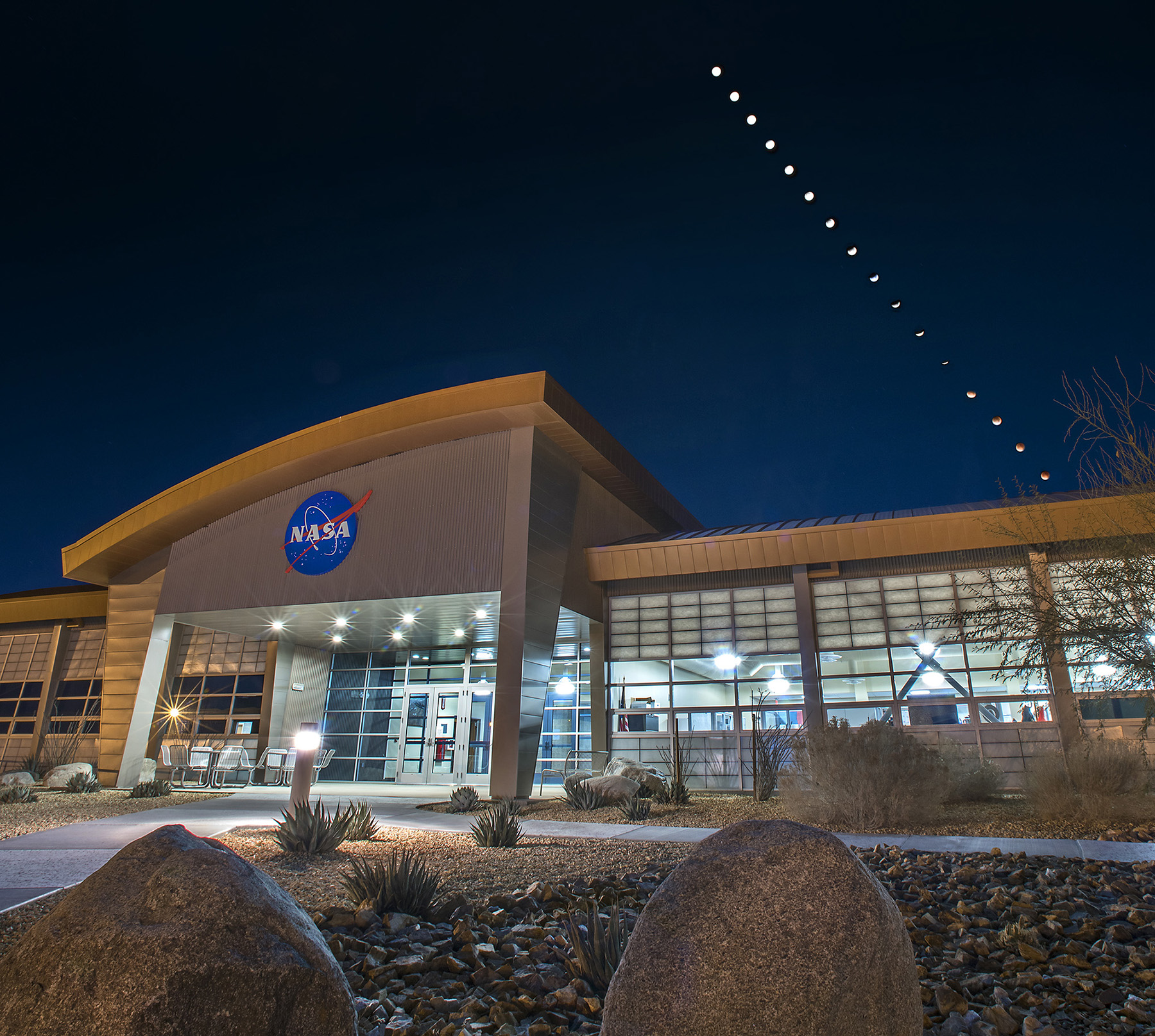 A long-exposure photo shows the phases of the moon over a NASA building