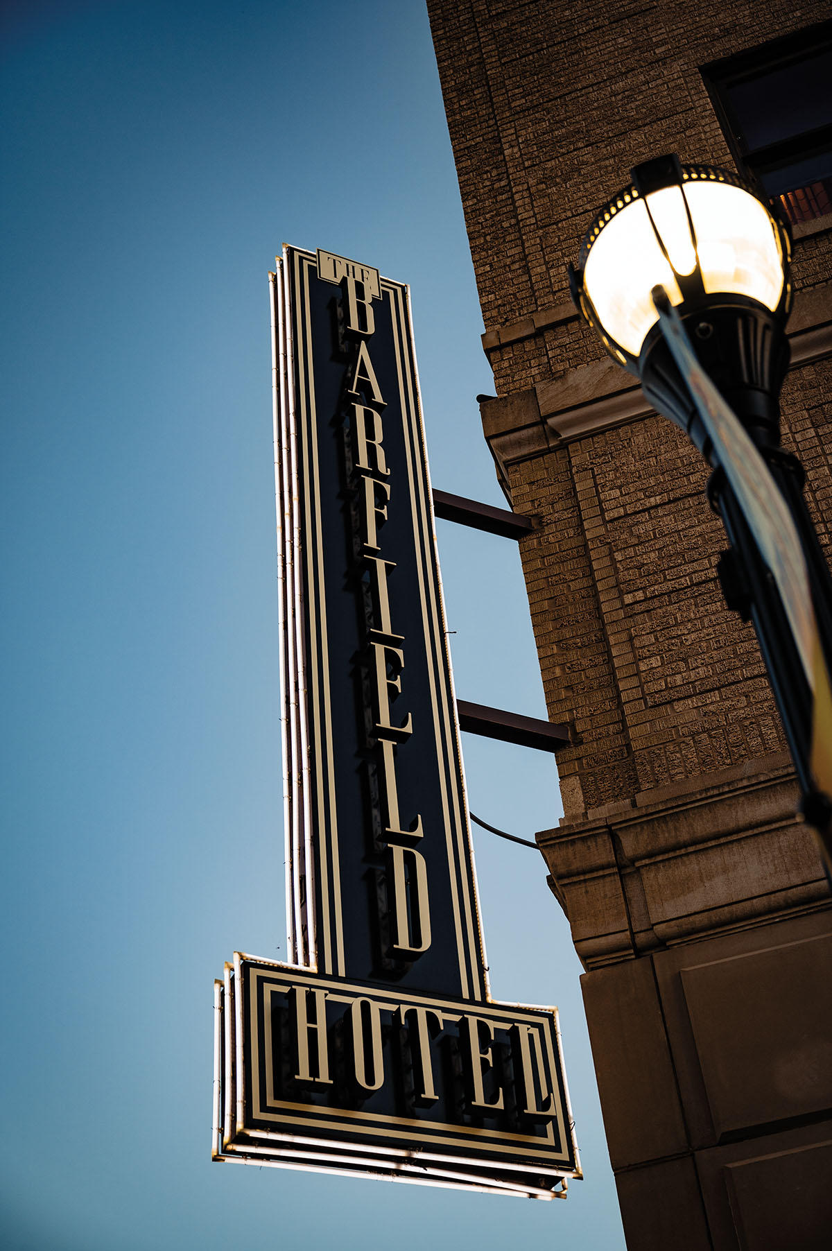 A midcentury styled sign reading "The Barfield Hotel" on the exterior of a brick building