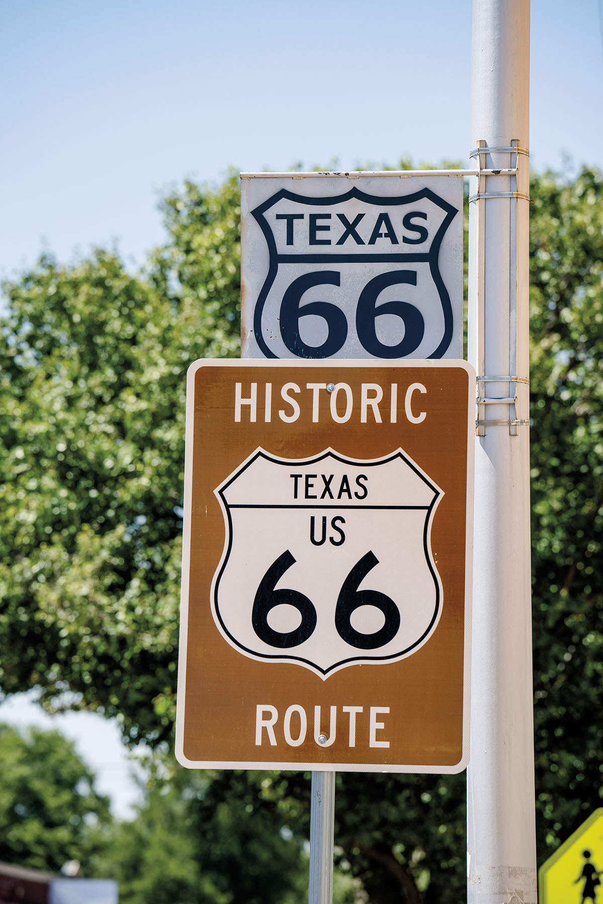 A brown sign reading "Historic Route 66" in front of a smaller white sign reading "Texas 66"