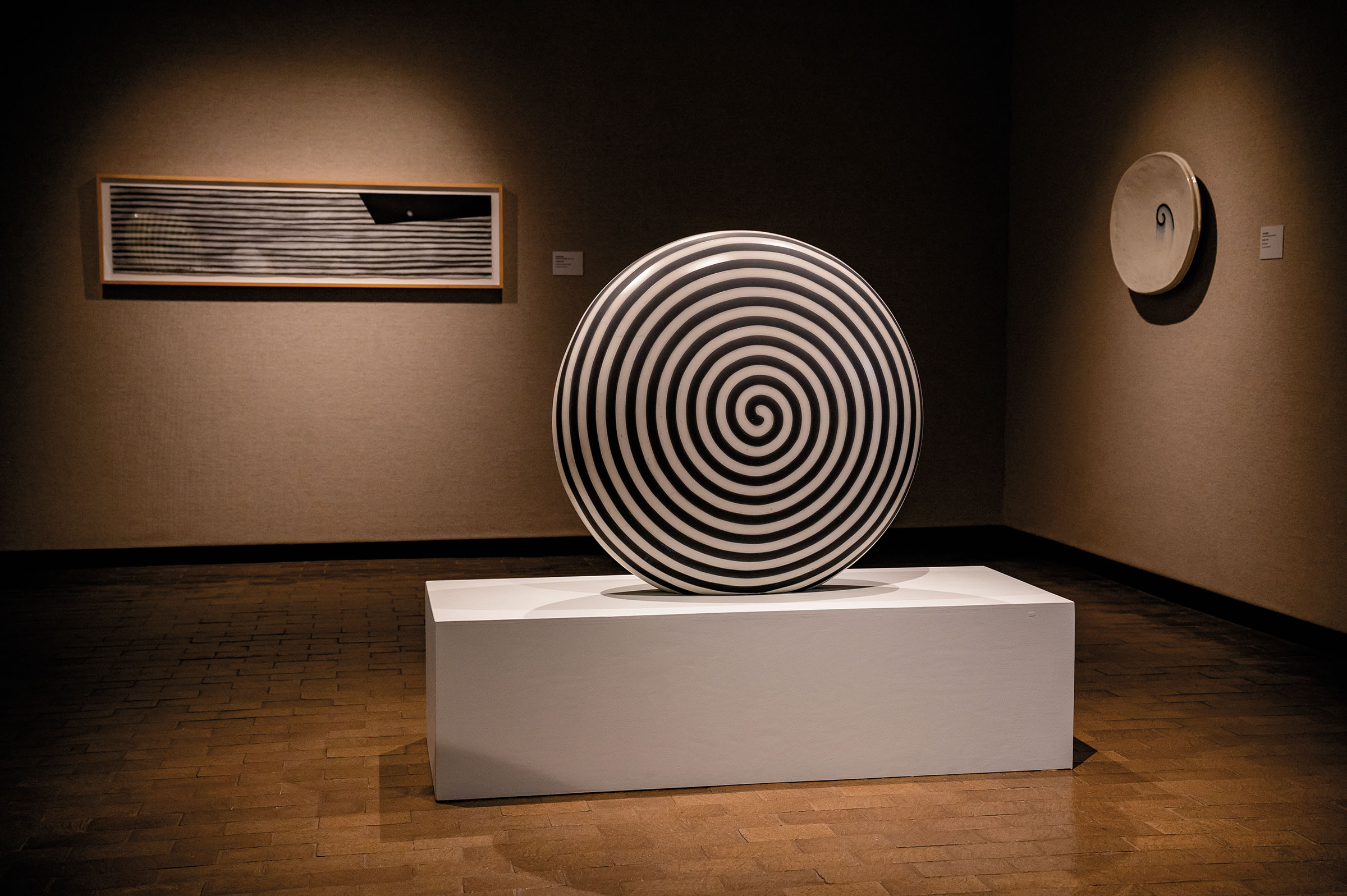 A large circular sculpture painted in a black and white spiral