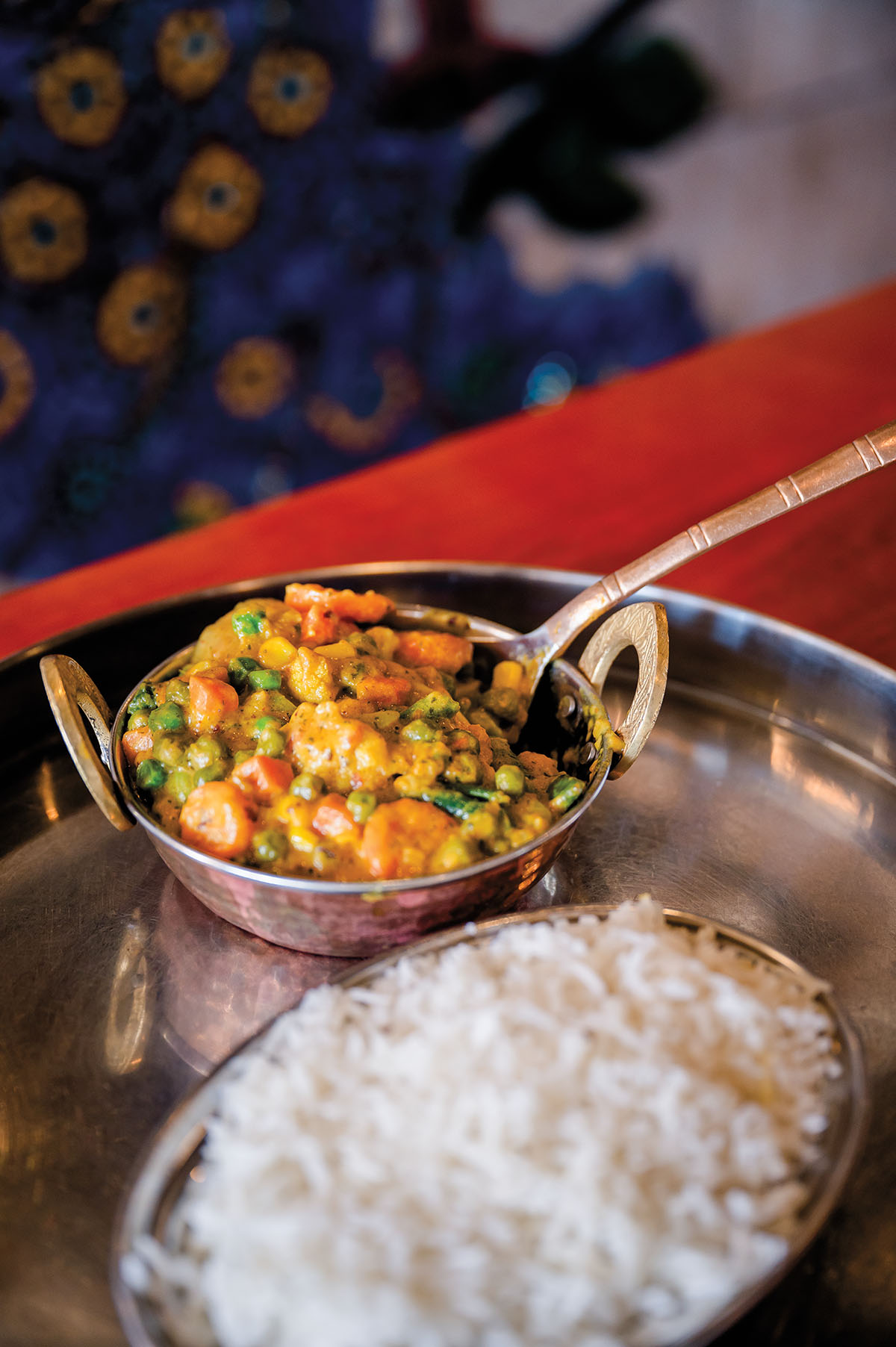 Small silver platters of white rice and a vegetable dish