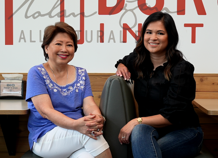 Two women sit in chairs looking at the camera