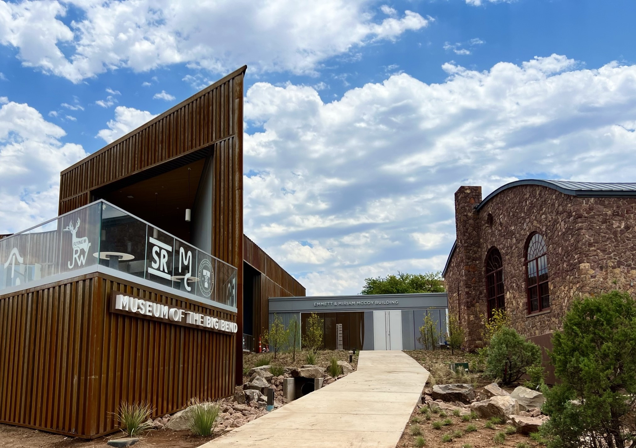 A large, brown modern building with a sign that reads "Museum of the Big Bend" with the sky in the background.