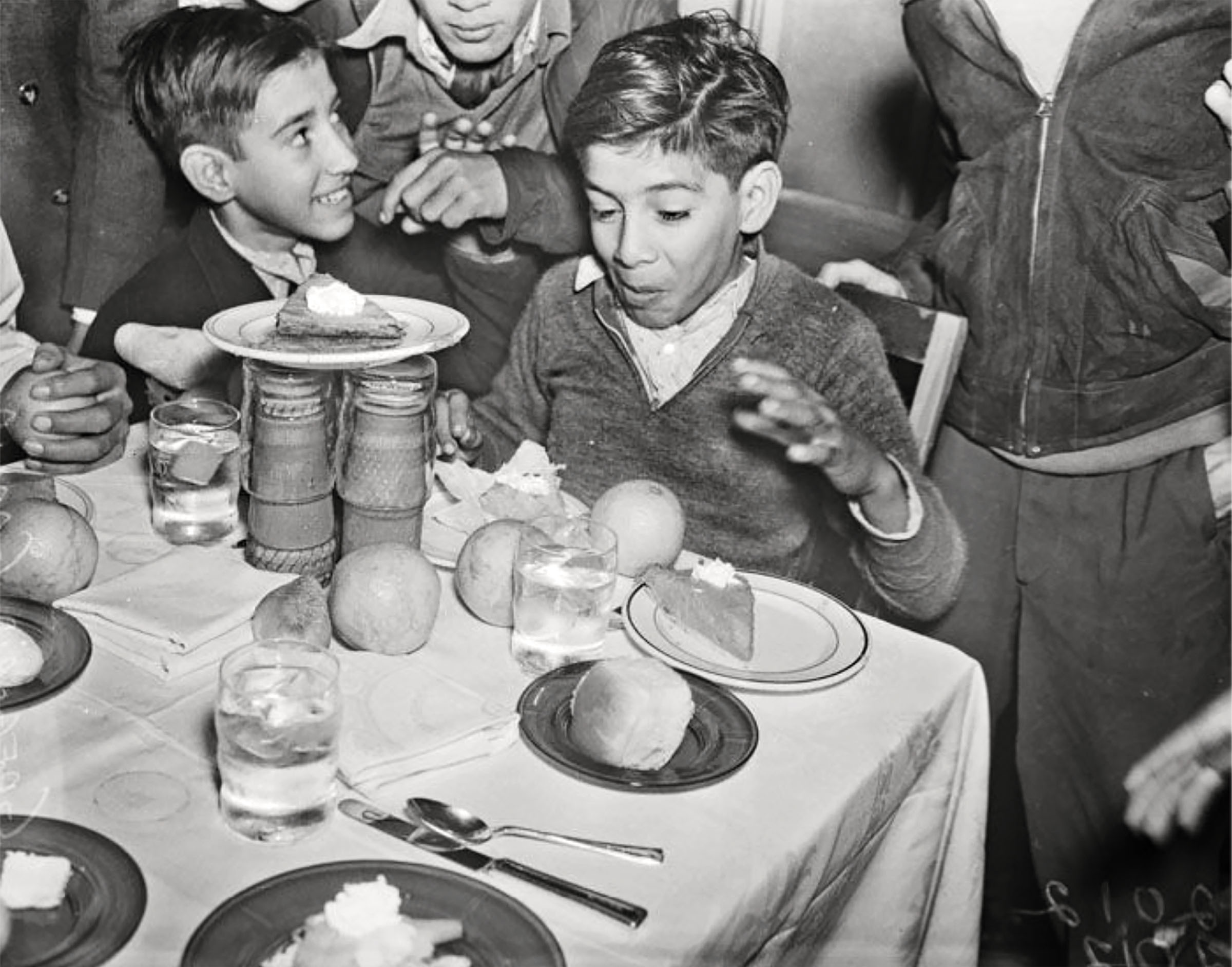 A young man makes an excited expression as he looks at a table with a Christmas feast