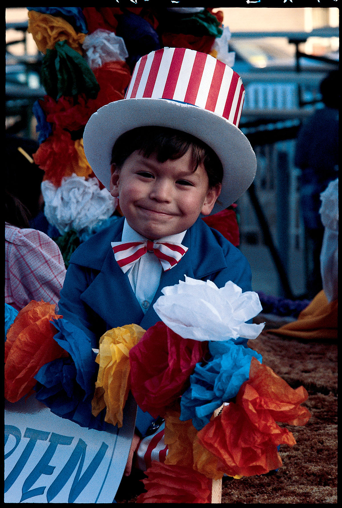 A child wears a patriotic outfit including a red and white striped hat