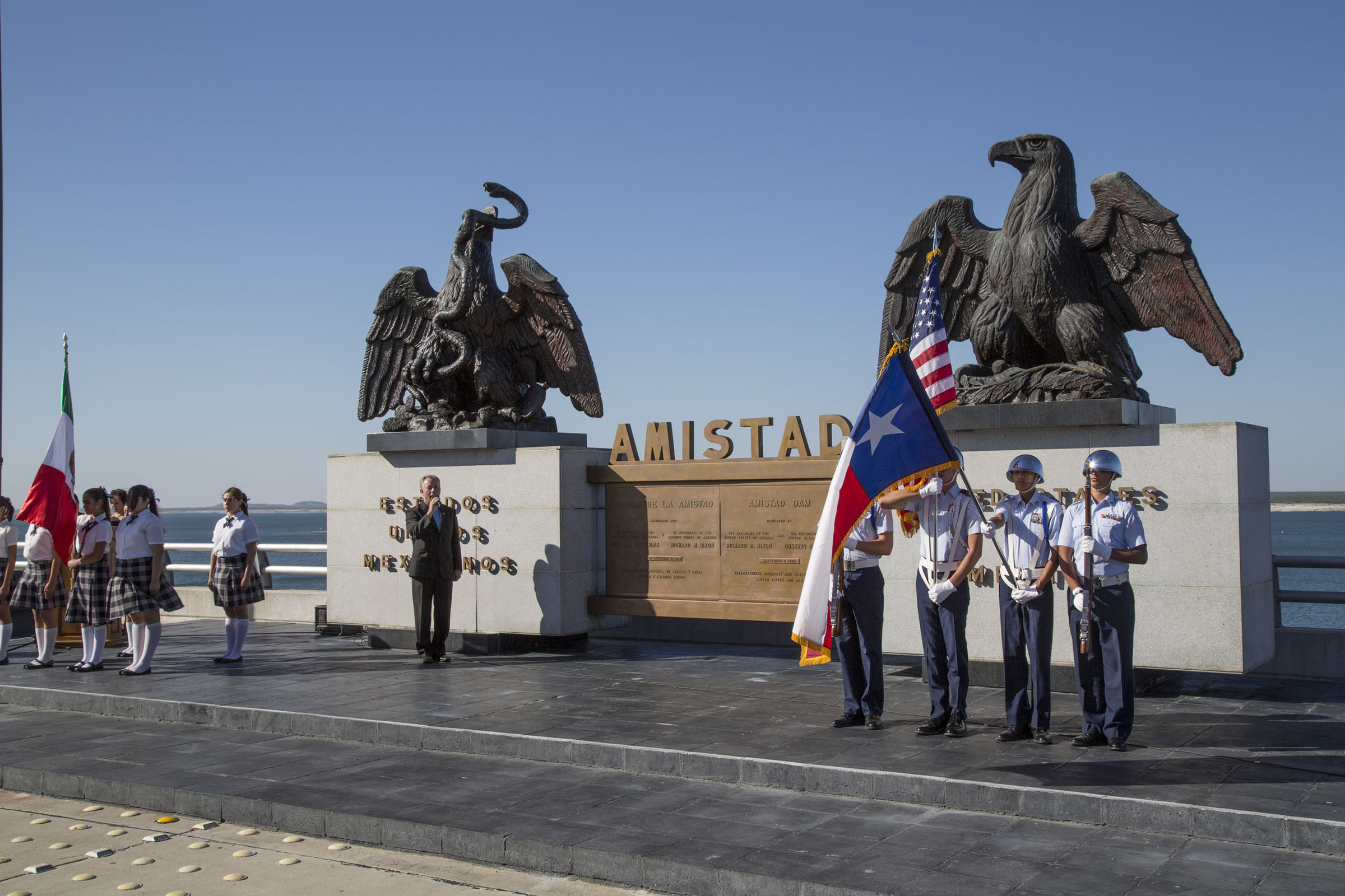 Two large eagle statues on concrete bases, with an "Amistad" sign between