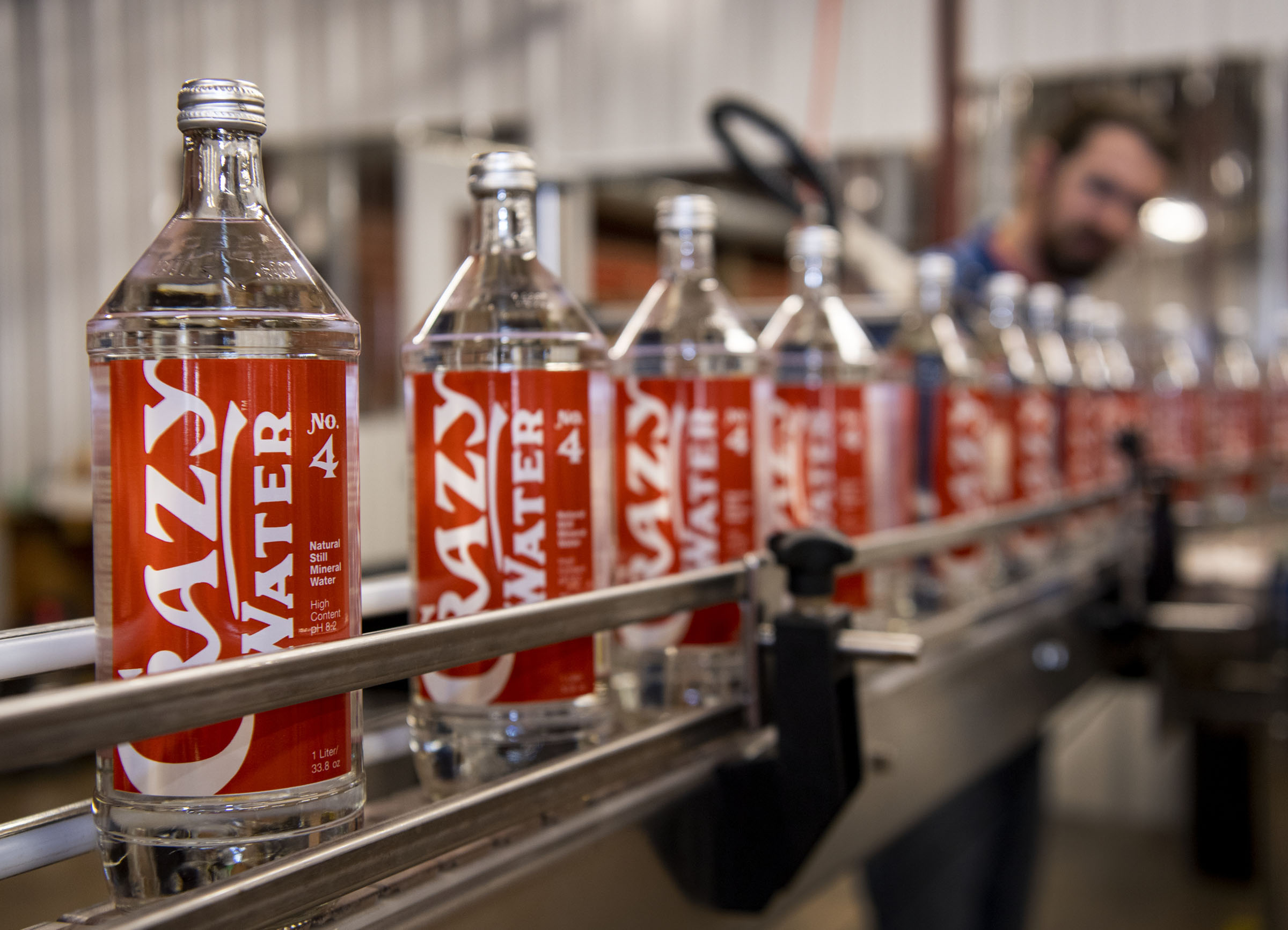 Bottled water with red labels in a water-filling factory