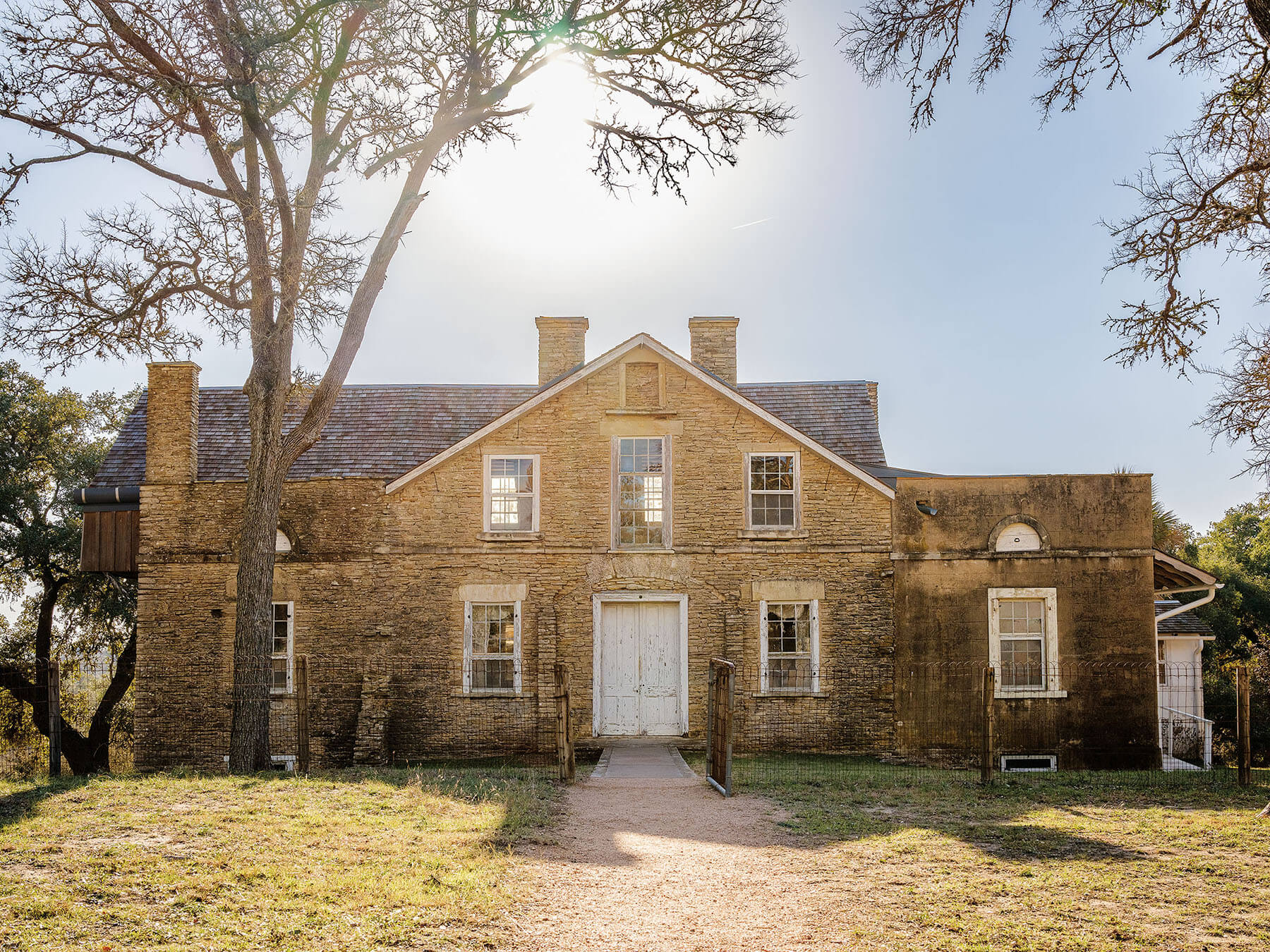 The exterior of a stone building under blue sky
