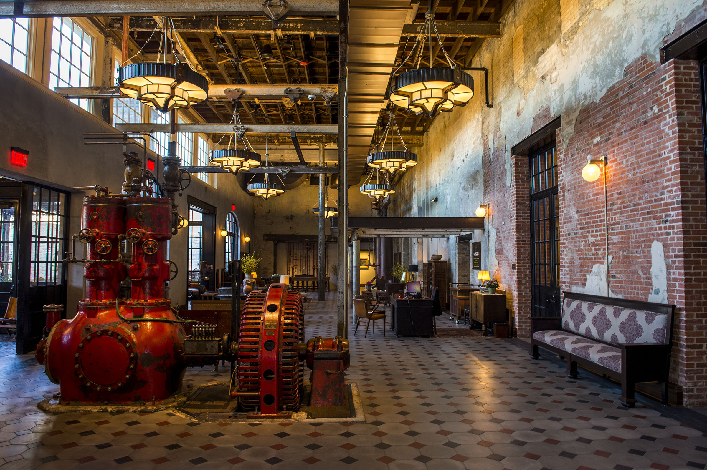 Large industrial fixtures and brick walls inside of a hotel lobby